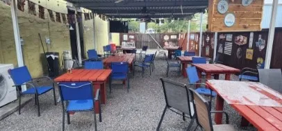 Outdoor patio space featuring a covered roof, gravel flooring, and perimeter fencing