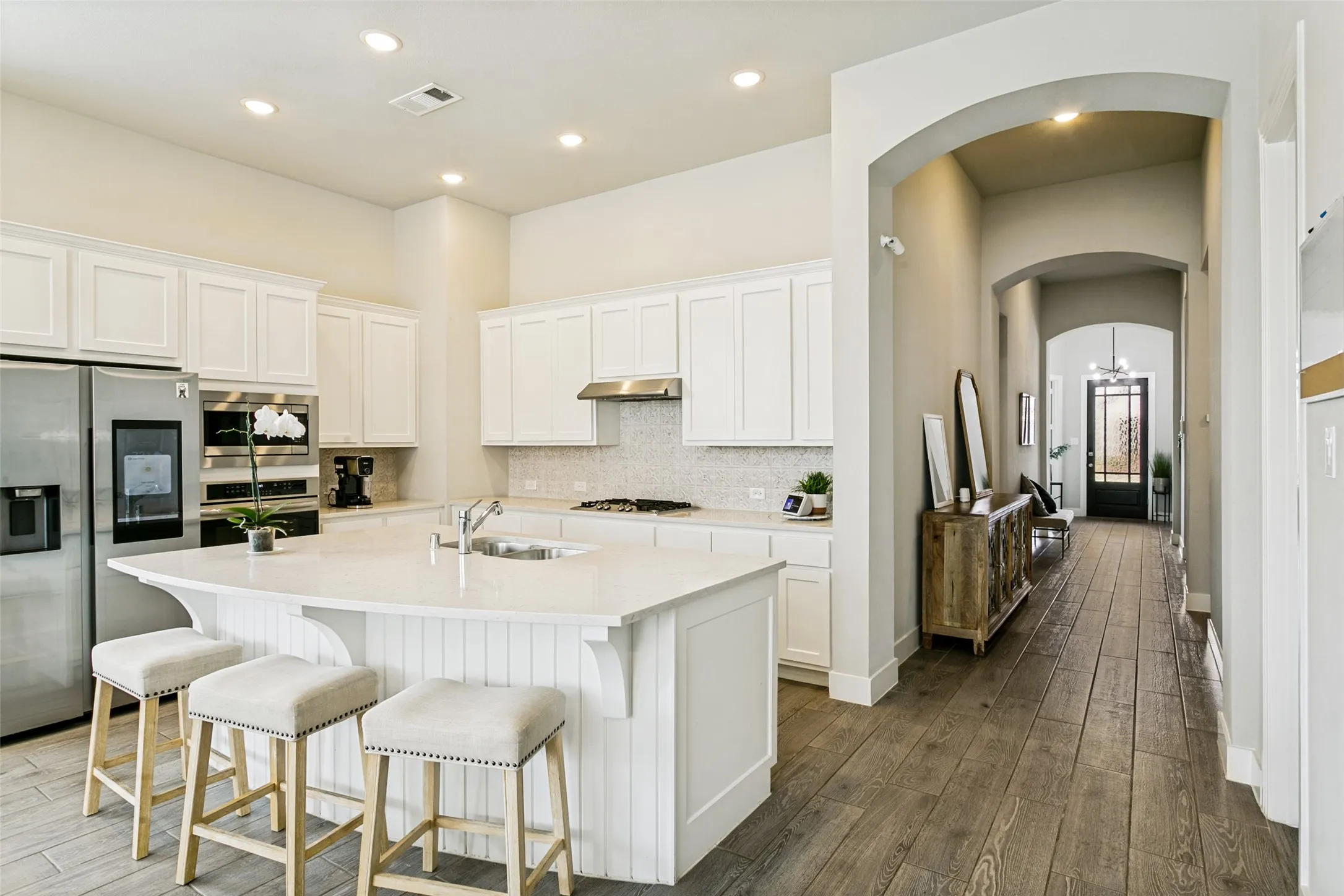 Kitchen featuring a central island with white paneling and a light-toned countertop
