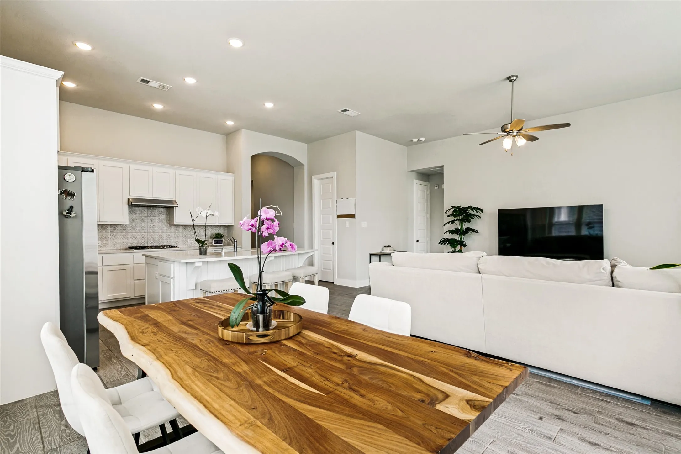Open-concept layout featuring wood-finish flooring, recessed lighting, and a modern ceiling fan
