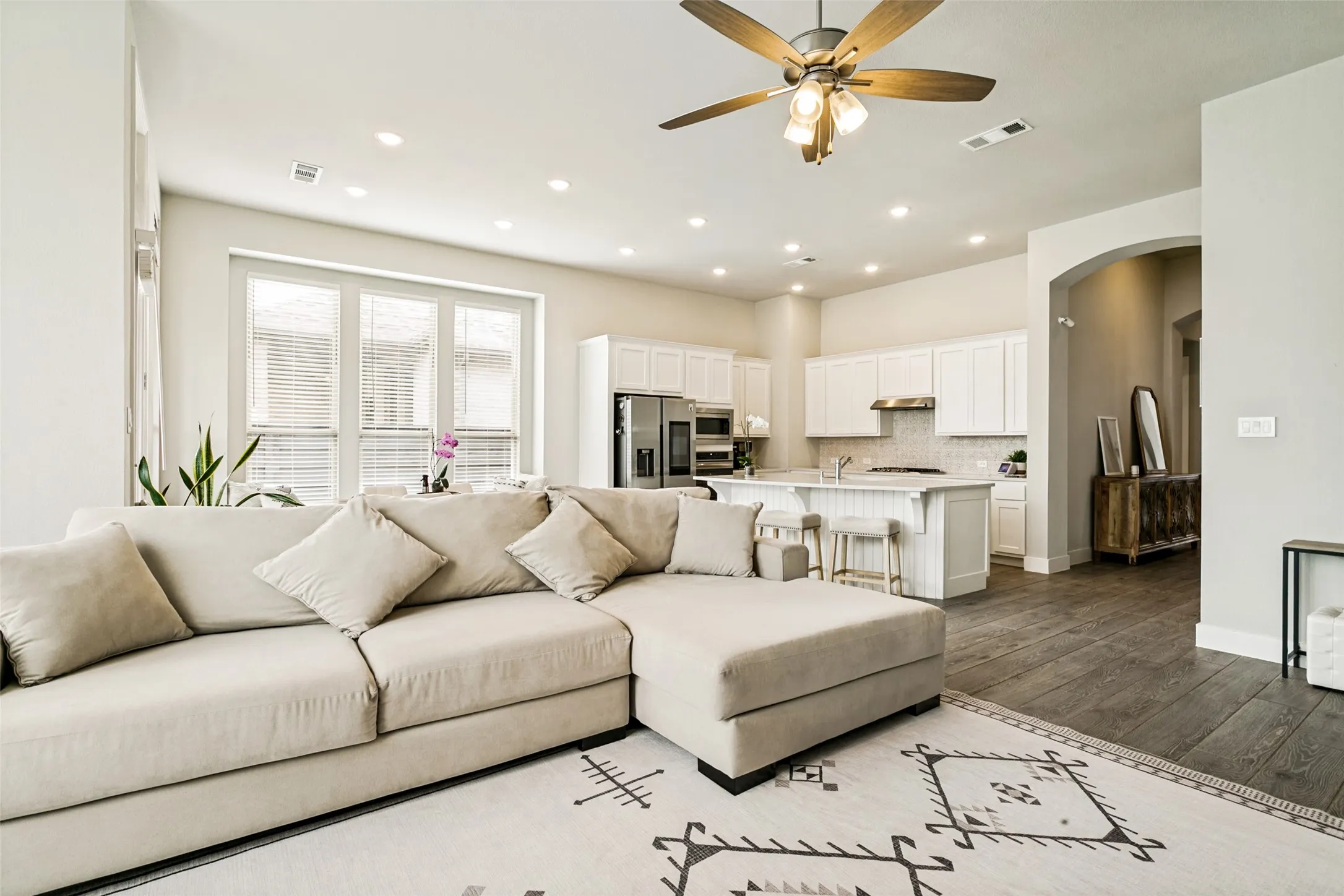 Open-concept living space featuring wood-finish flooring and recessed lighting