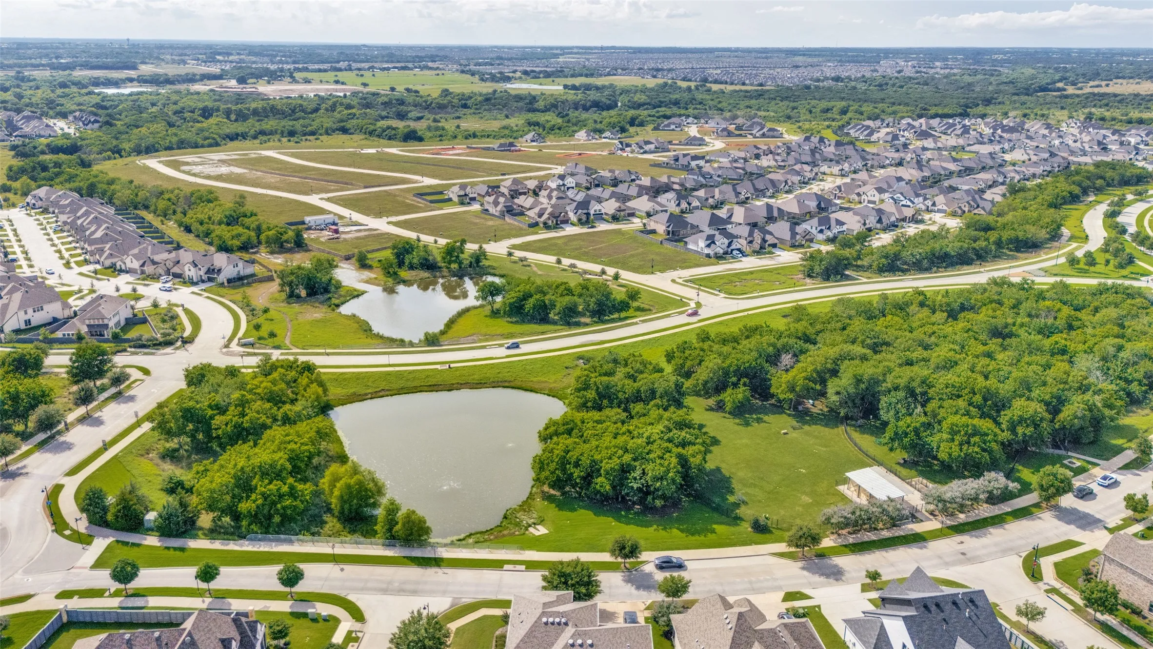 Aerial representation of a residential development featuring established homes, undeveloped lots, and natural green spaces