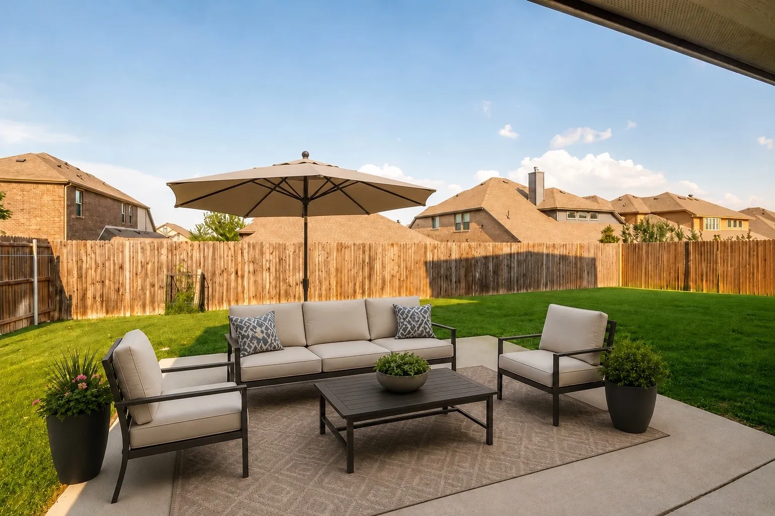 Expansive backyard featuring a concrete patio, a large green lawn, and a wood privacy fence