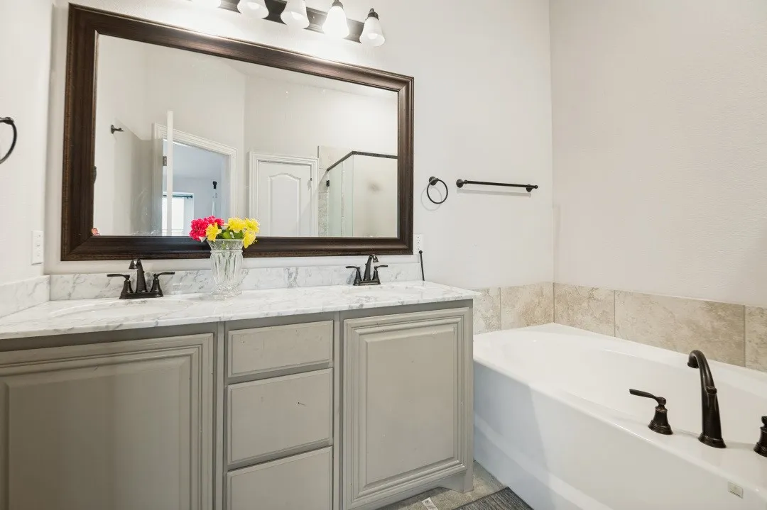 Bathroom featuring a double vanity with light gray cabinetry and a light-toned countertop
