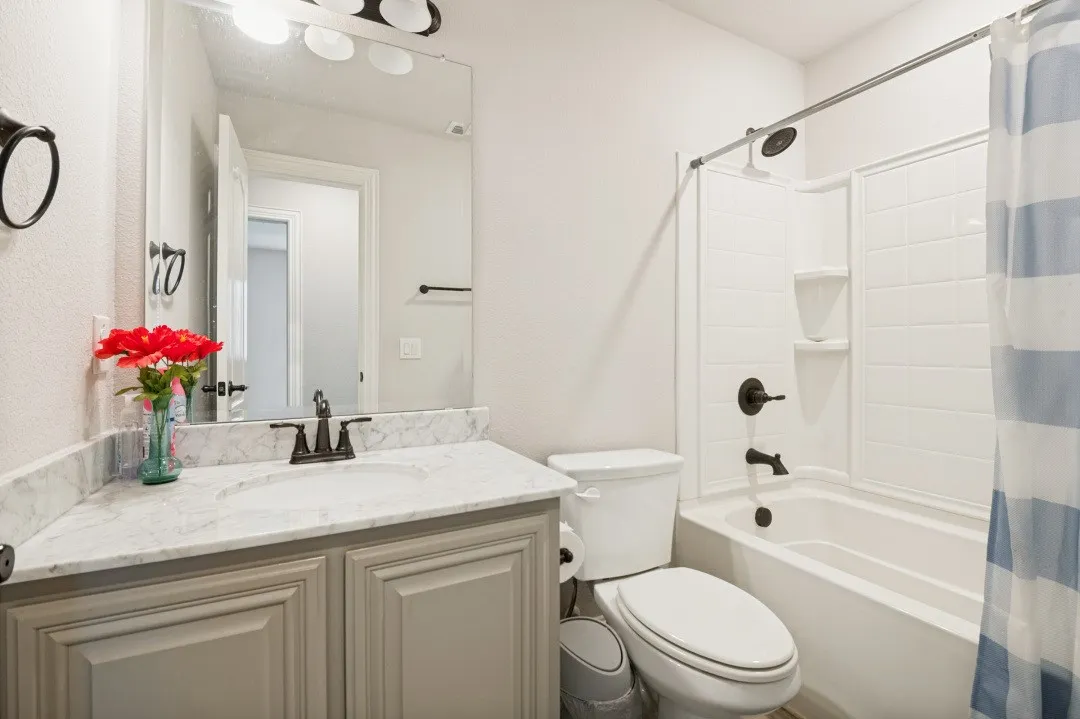 Bathroom featuring a light-colored vanity with a white countertop, an undermount sink, and dark bronze fixtures