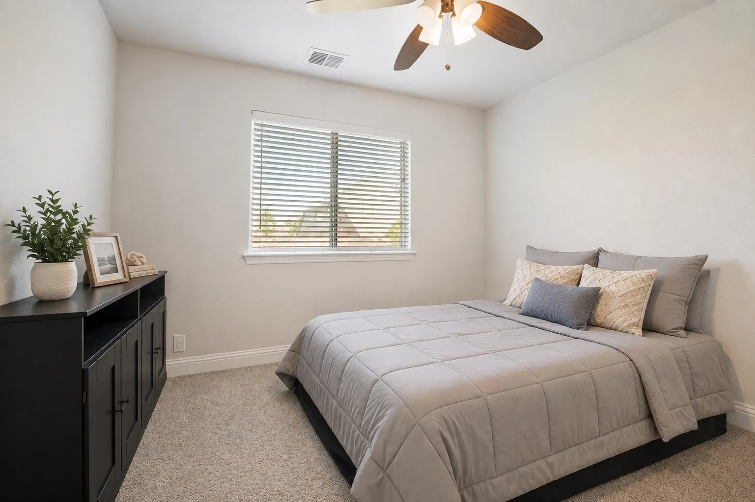 Carpeted bedroom featuring a ceiling fan with integrated lighting, a window with blinds, and white baseboards