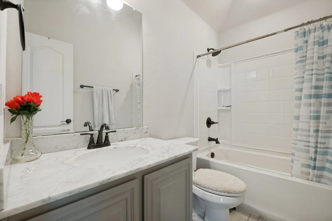 Bathroom featuring a vanity with a light-toned countertop, a built-in sink, and dark bronze-finish fixtures