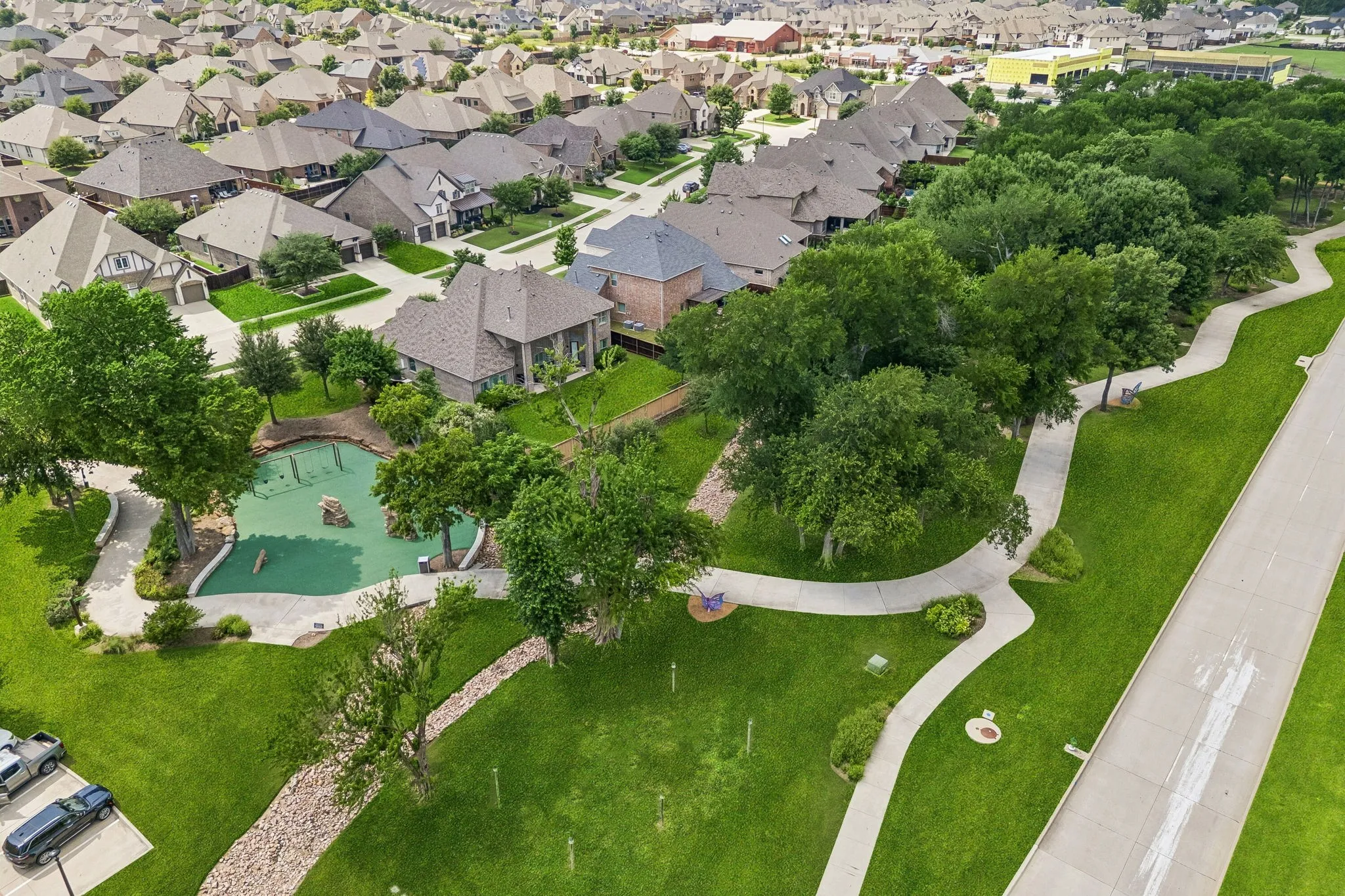 Expansive green spaces featuring walking paths, mature trees, and a community playground