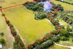 Expansive acreage featuring a substantial cleared field and a natural pond