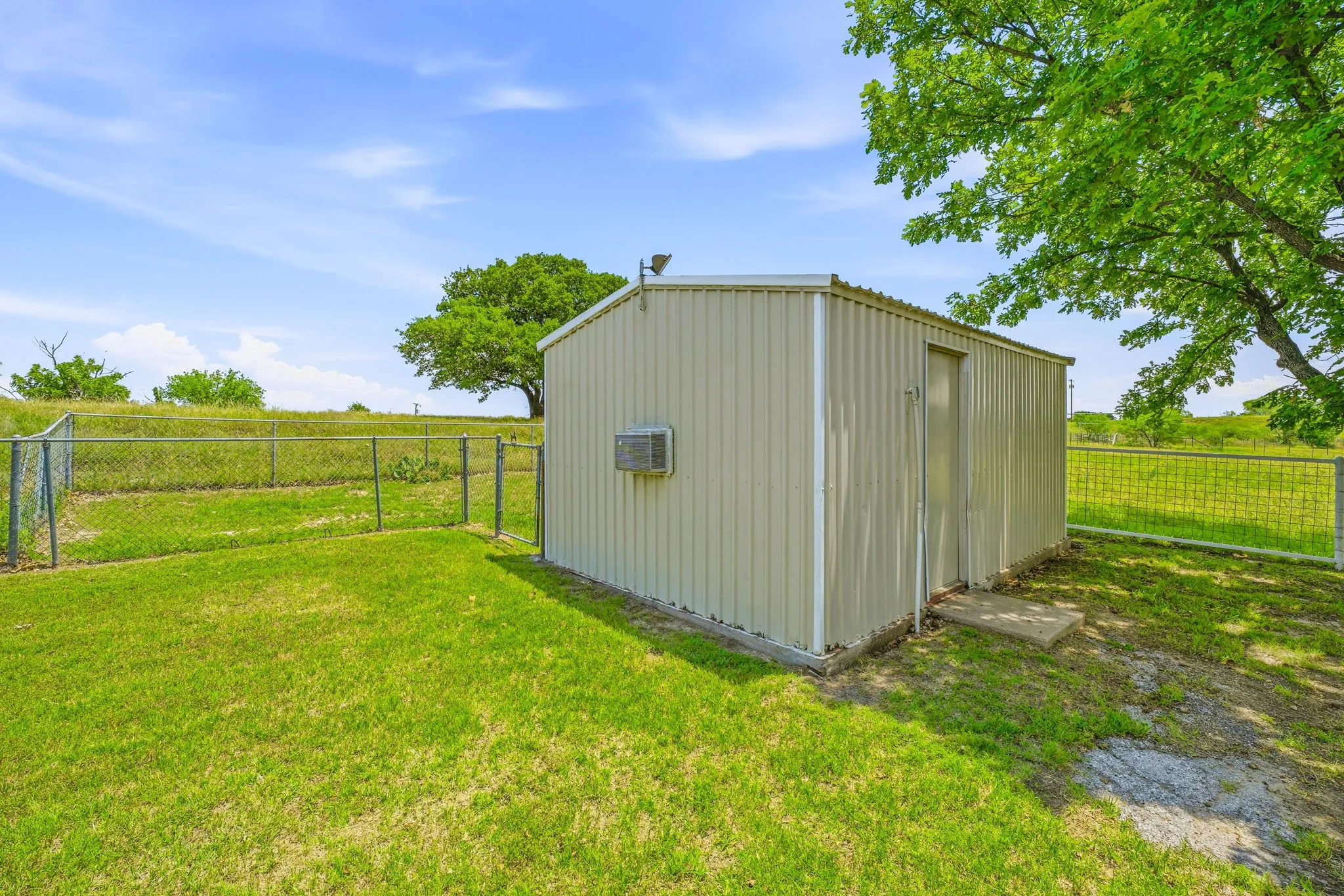 Metal storage building featuring corrugated siding and a window air conditioning unit