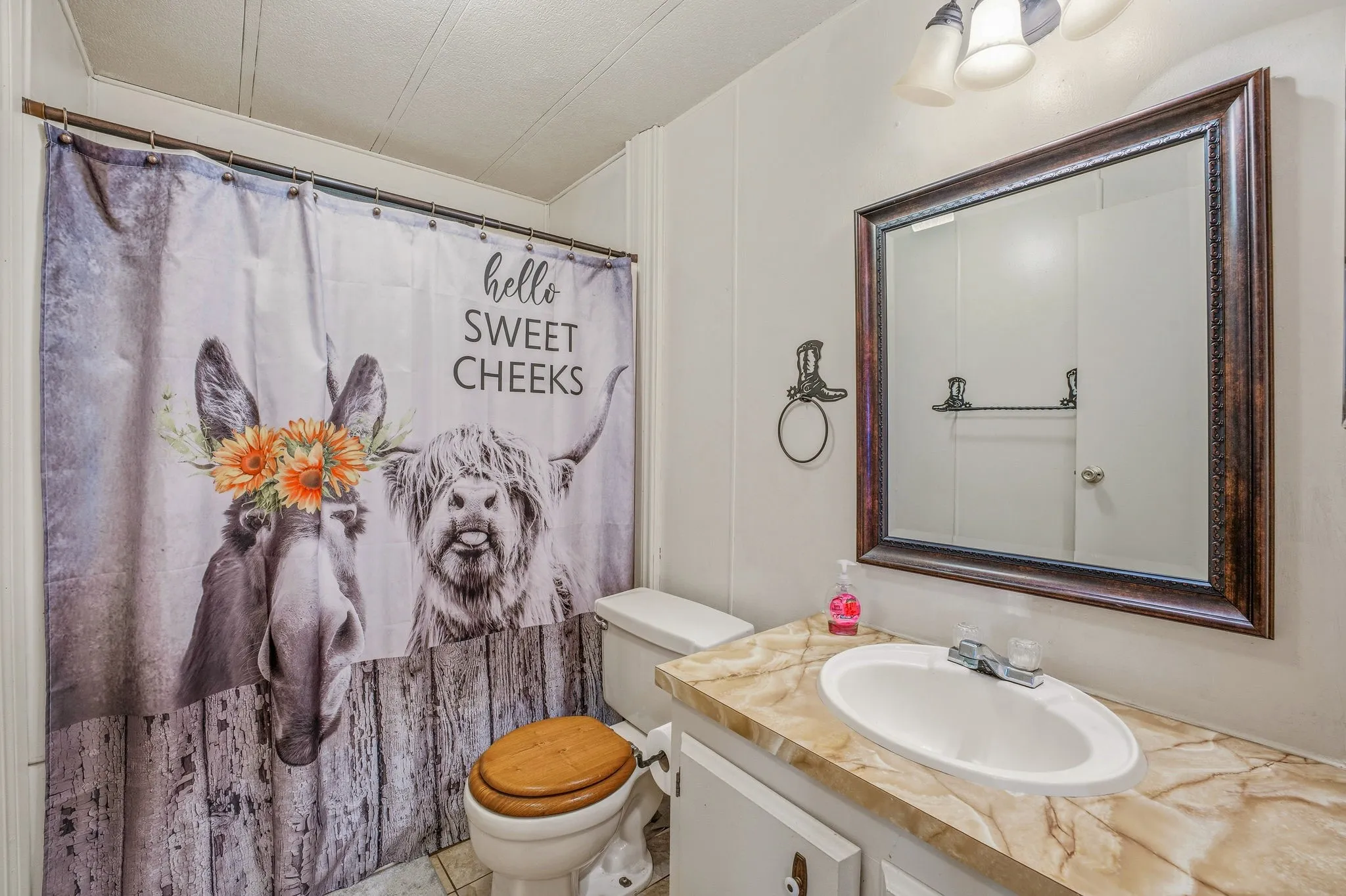 Bathroom vanity featuring a built-in sink and a large framed mirror with ornate detailing