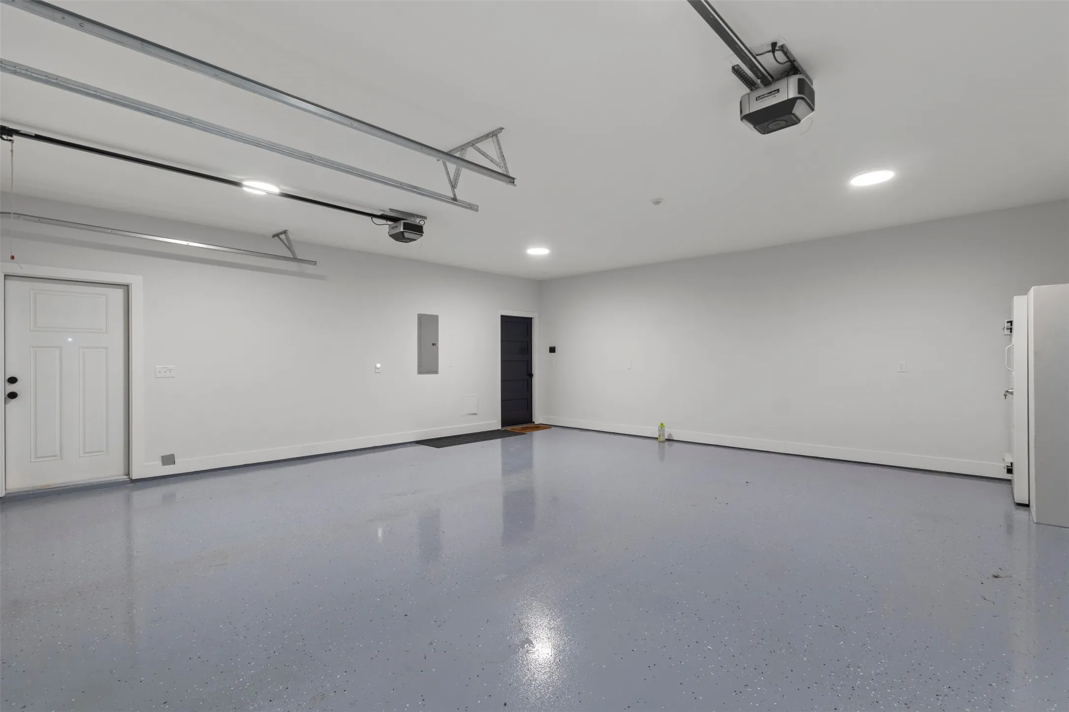 Oversized fully insulated 26x26 garage featuring 10x8 garage doors with very quiet linear operators, sleek finished floors, abundant lighting, and an EF-5 rated tornado pod—offering secure, functional space with added peace of mind.