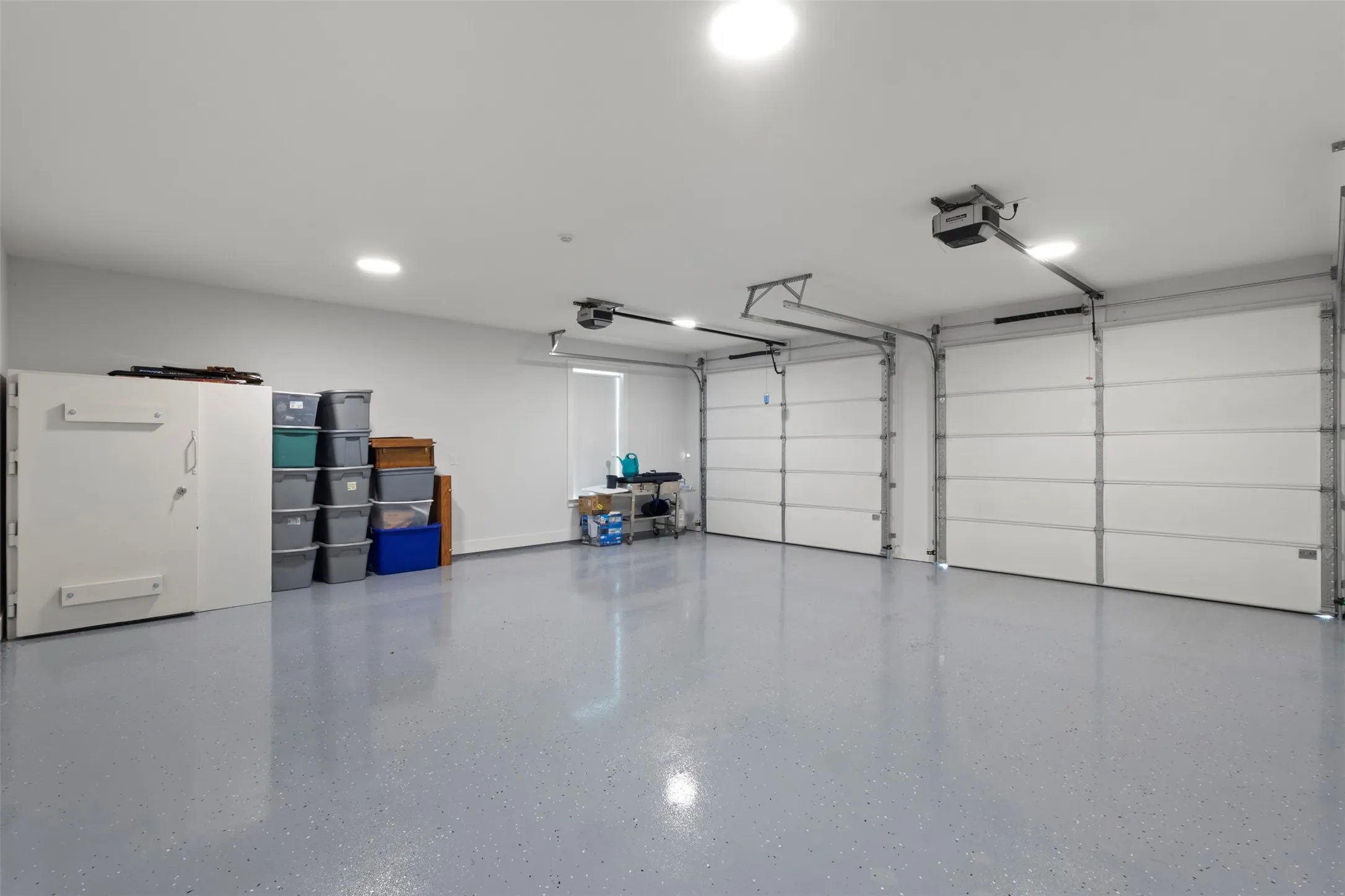 Oversized fully insulated 26x26 garage featuring 10x8 garage doors with very quiet linear operators, sleek finished floors, abundant lighting, and an EF-5 rated tornado pod—offering secure, functional space with added peace of mind.
