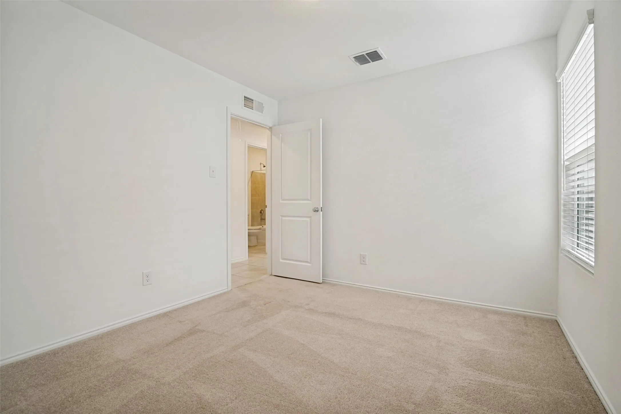 Neutral tone carpeting with white baseboards throughout