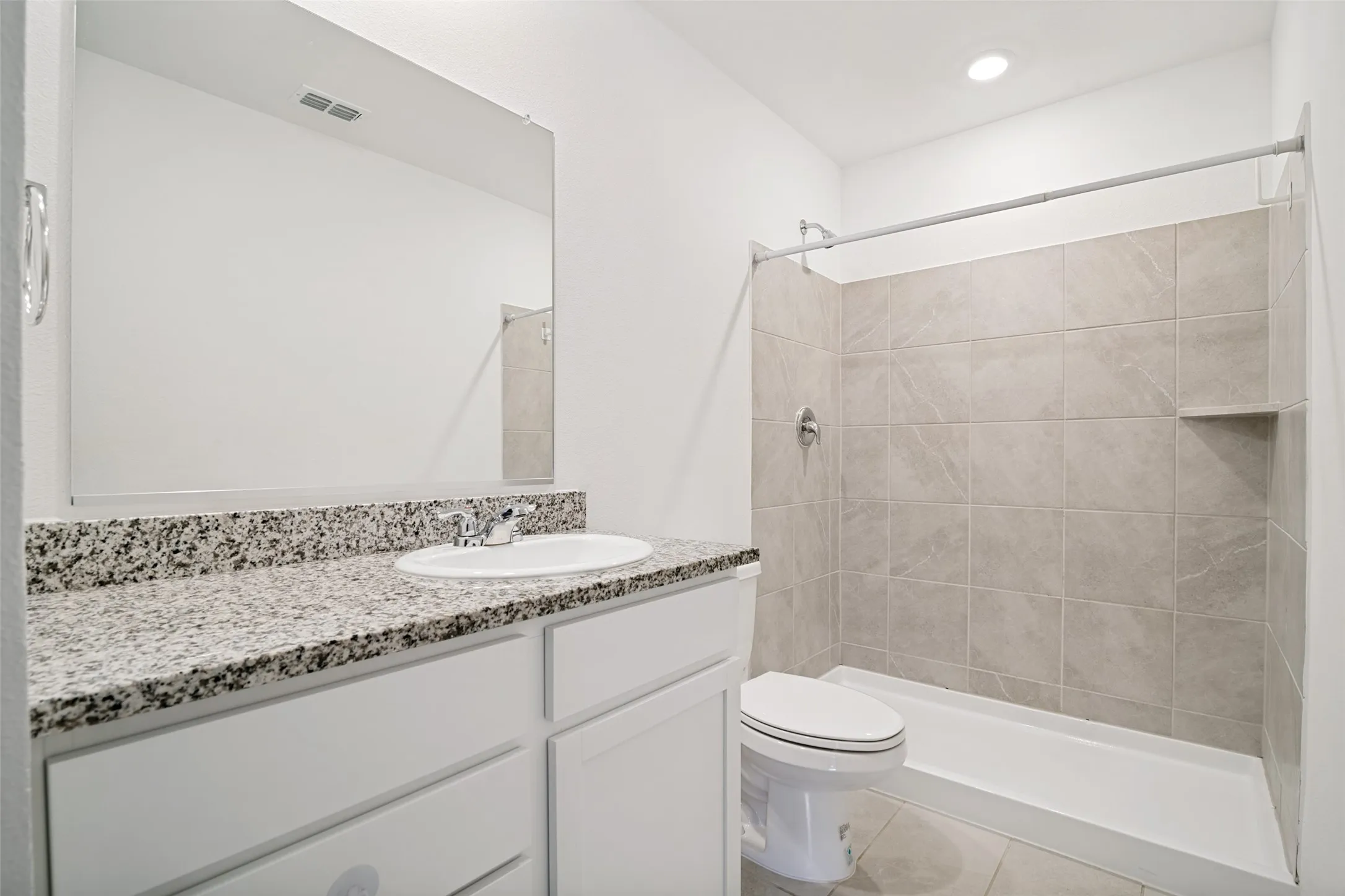 Bathroom featuring a white vanity with granite-style countertop, integrated sink, and chrome faucet
