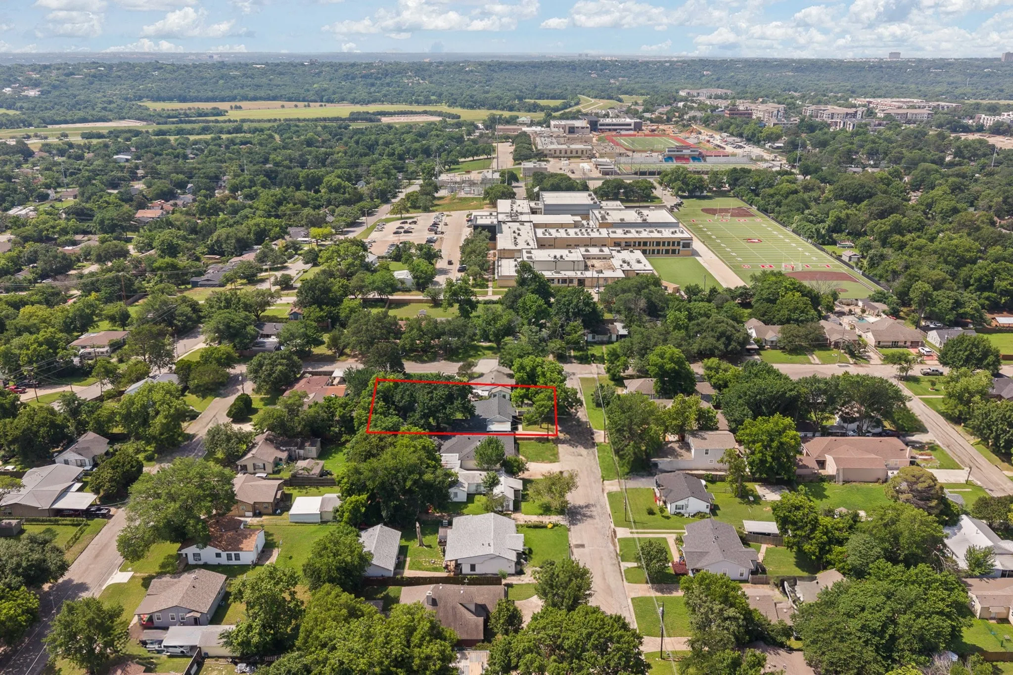 Aerial perspective showcasing a residential neighborhood with mature tree coverage