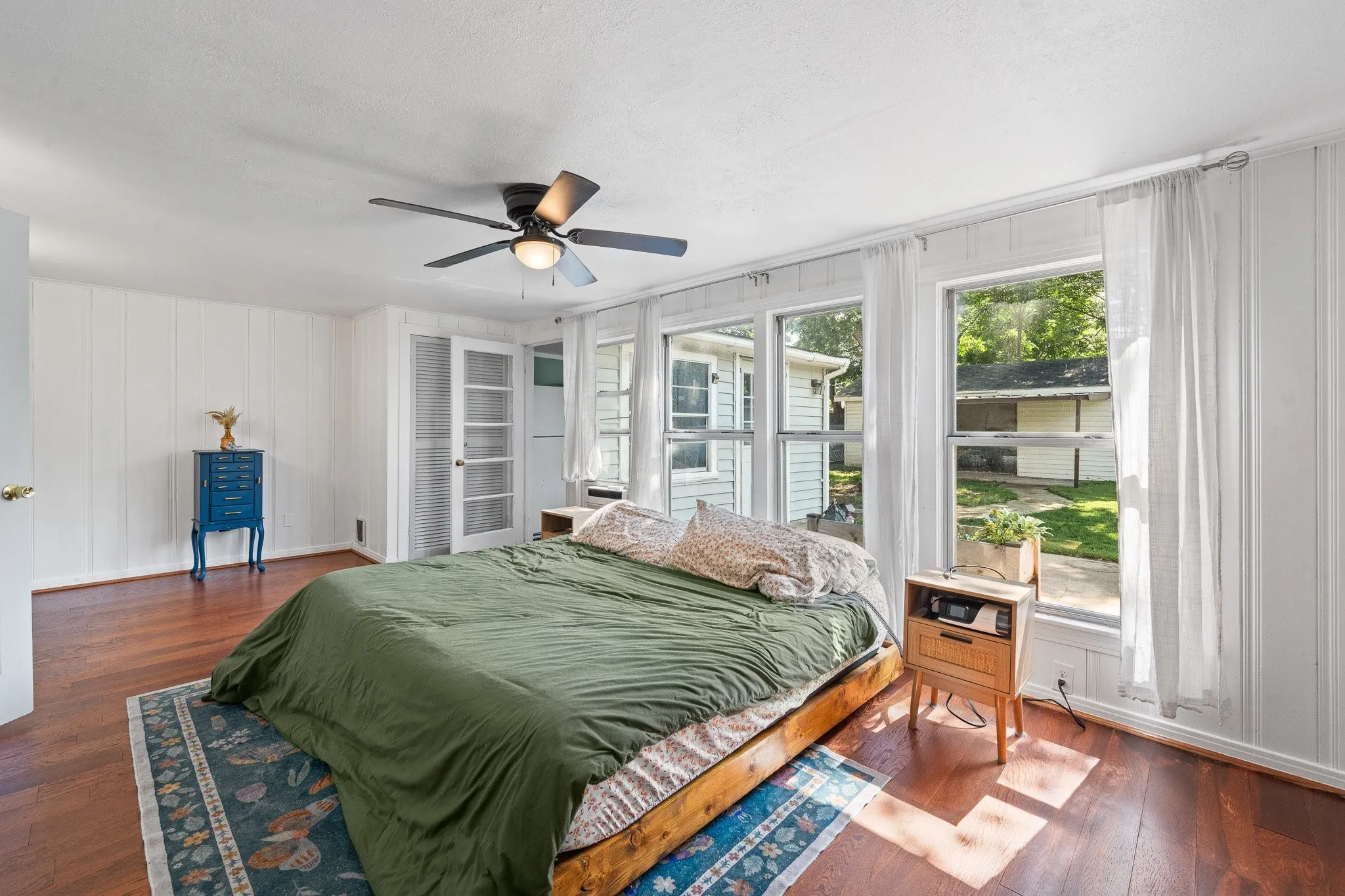 Interior room featuring rich wood-finish flooring and white vertical paneling