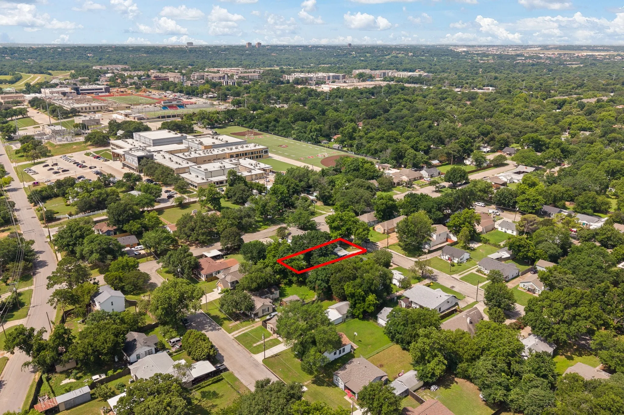 Aerial perspective showcasing a residential property within a tree-lined neighborhood