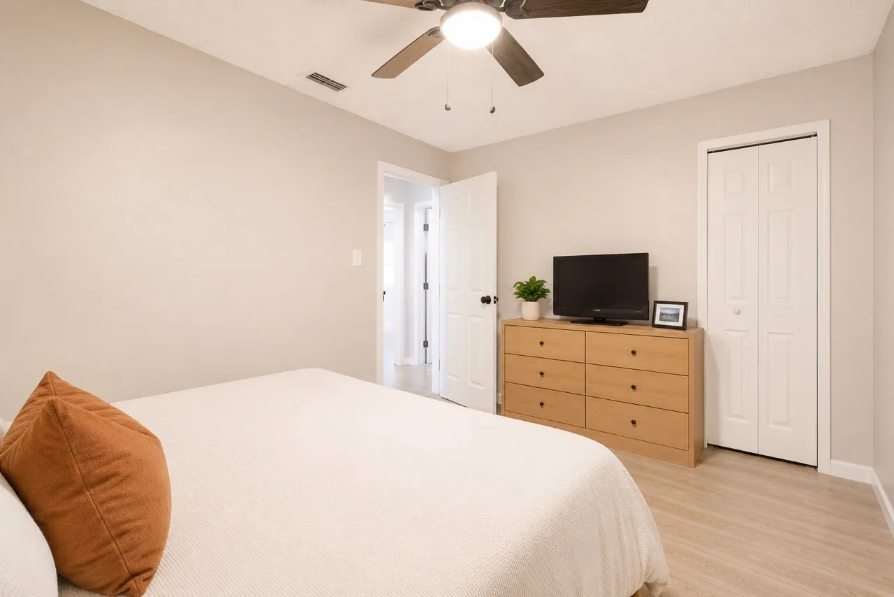 Bedroom featuring light wood-finish flooring, a ceiling fan with light fixture, and a bi-fold closet door