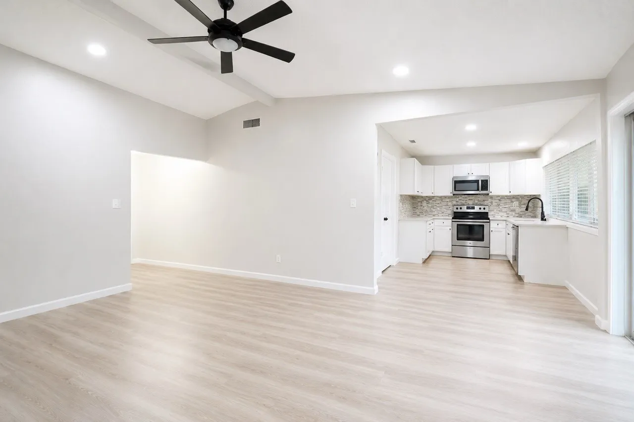 Vaulted ceiling with exposed beams, recessed lighting, and a contemporary ceiling fan