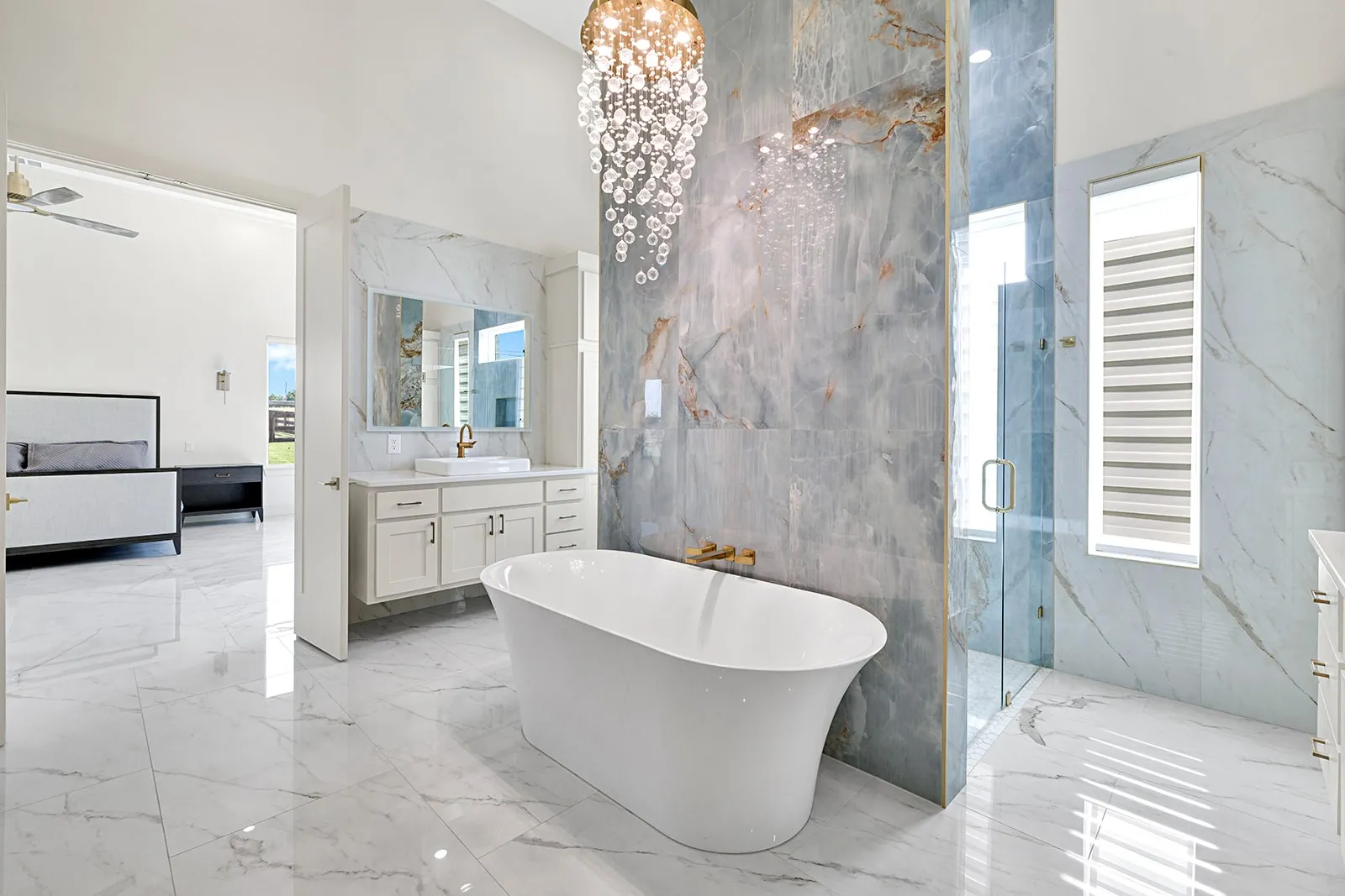 Freestanding soaking tub with gold-tone fixtures, complemented by a large walk-in shower with glass enclosure