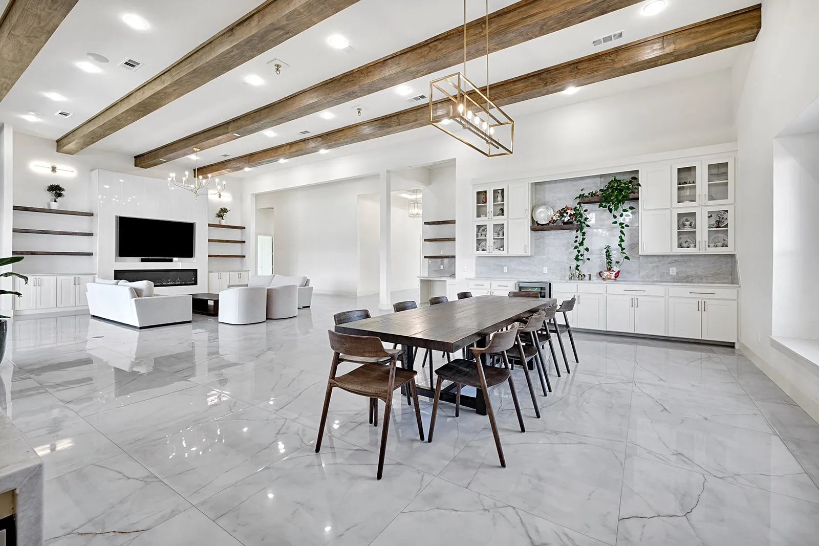 Expansive living area featuring large format tile flooring, exposed wood ceiling beams, and high ceilings