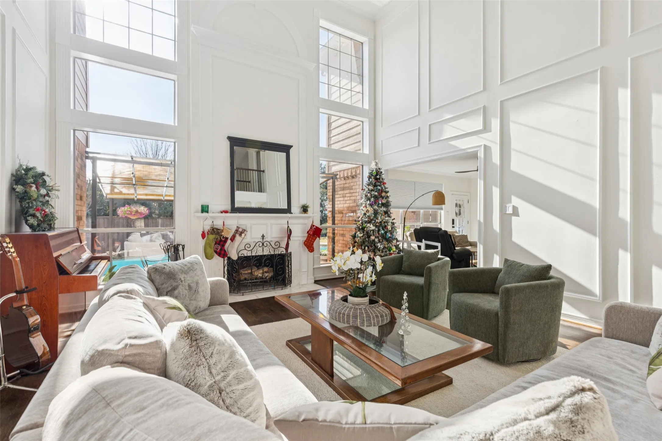 Vaulted living room featuring extensive window-paneled walls and wood-finish flooring