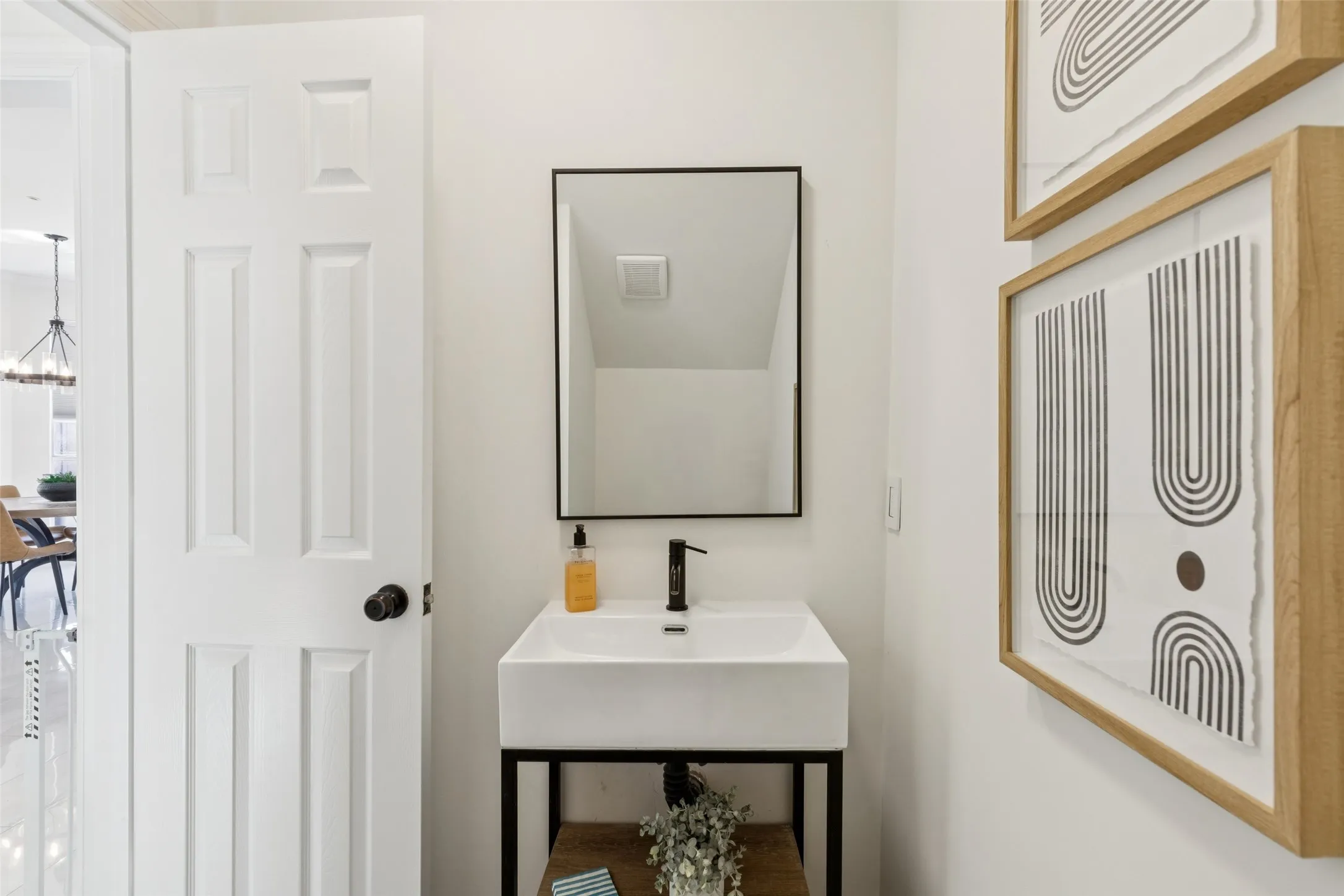 Modern rectangular vessel sink with a matte black faucet, set on a dark metal and wood-finish vanity