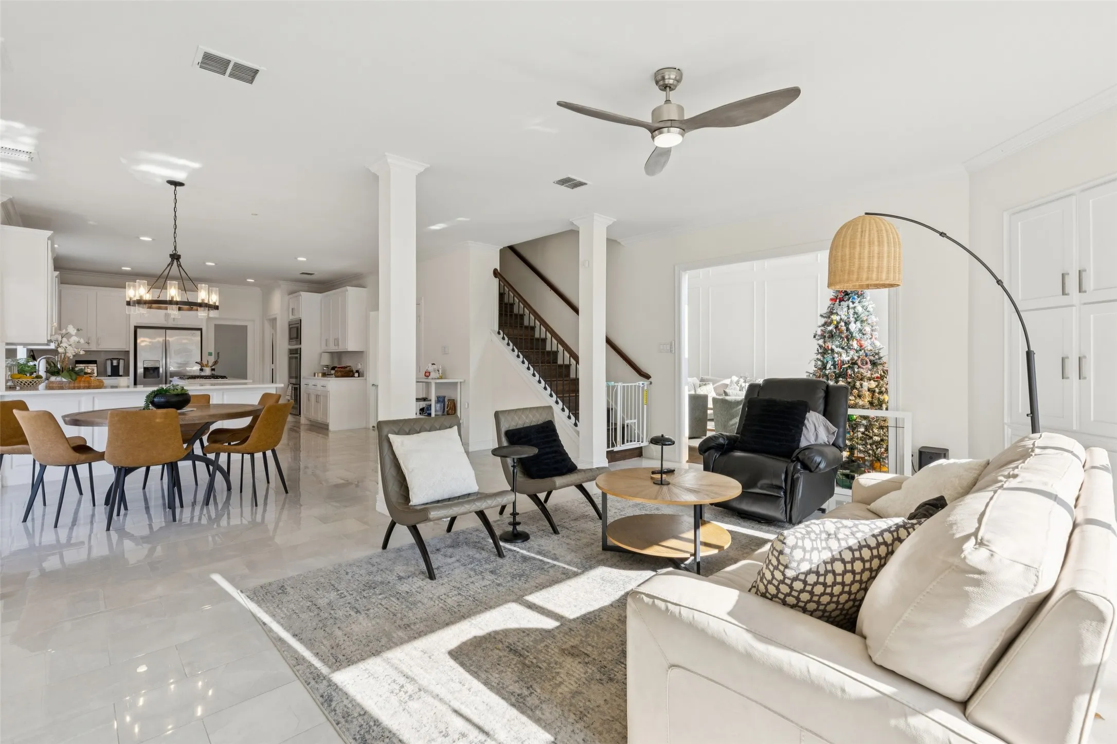 Spacious open-concept living area featuring light-toned flooring, recessed lighting, and a ceiling fan