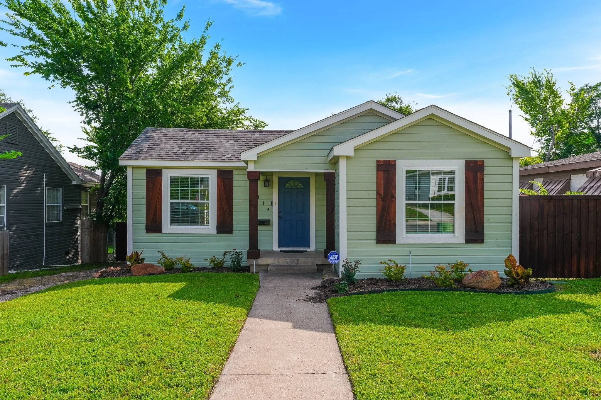 Green siding exterior with a blue entry door
