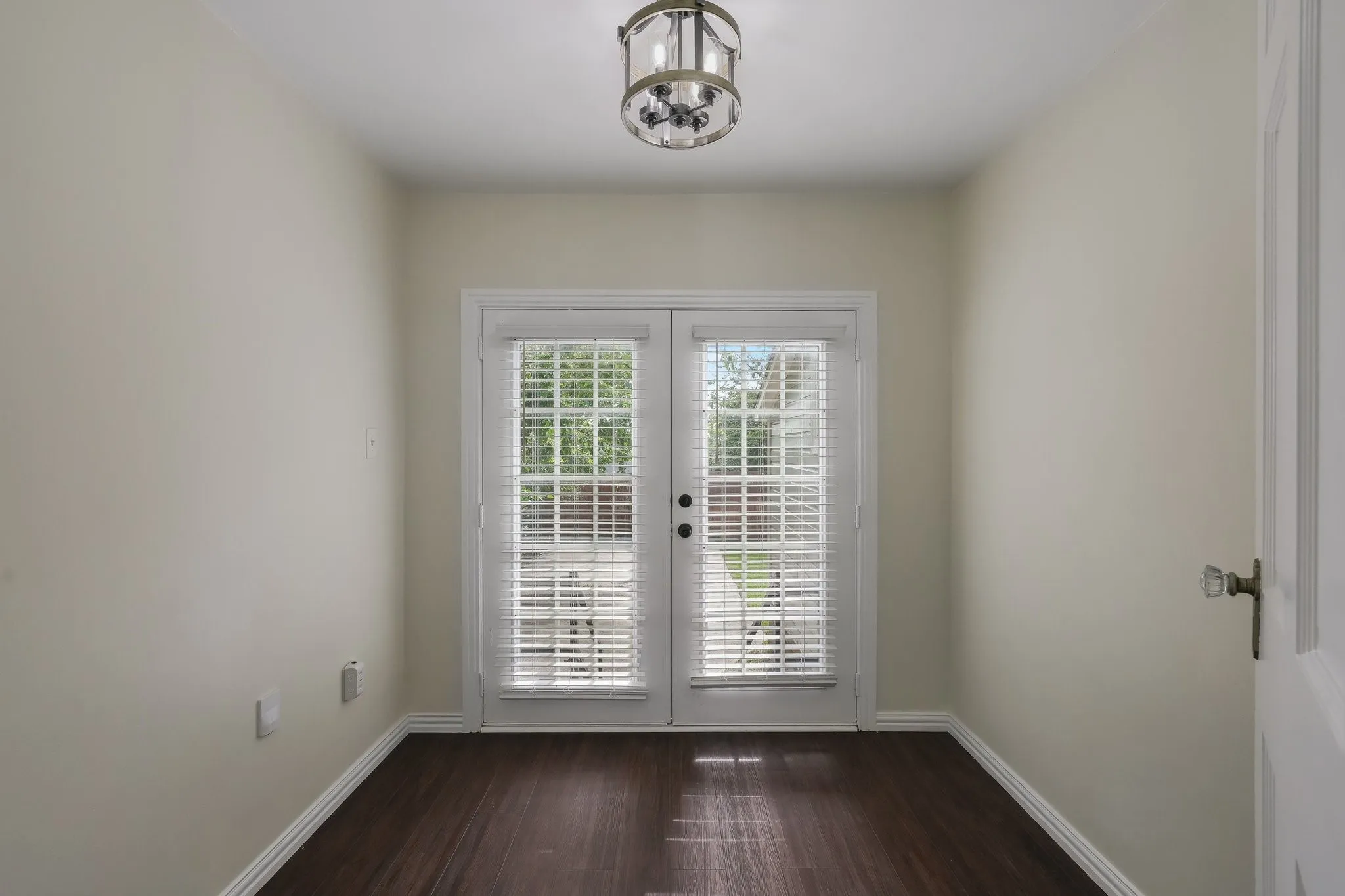 Space ideal for an office, reading or art room.  Light-toned walls, and a ceiling-mounted light fixture