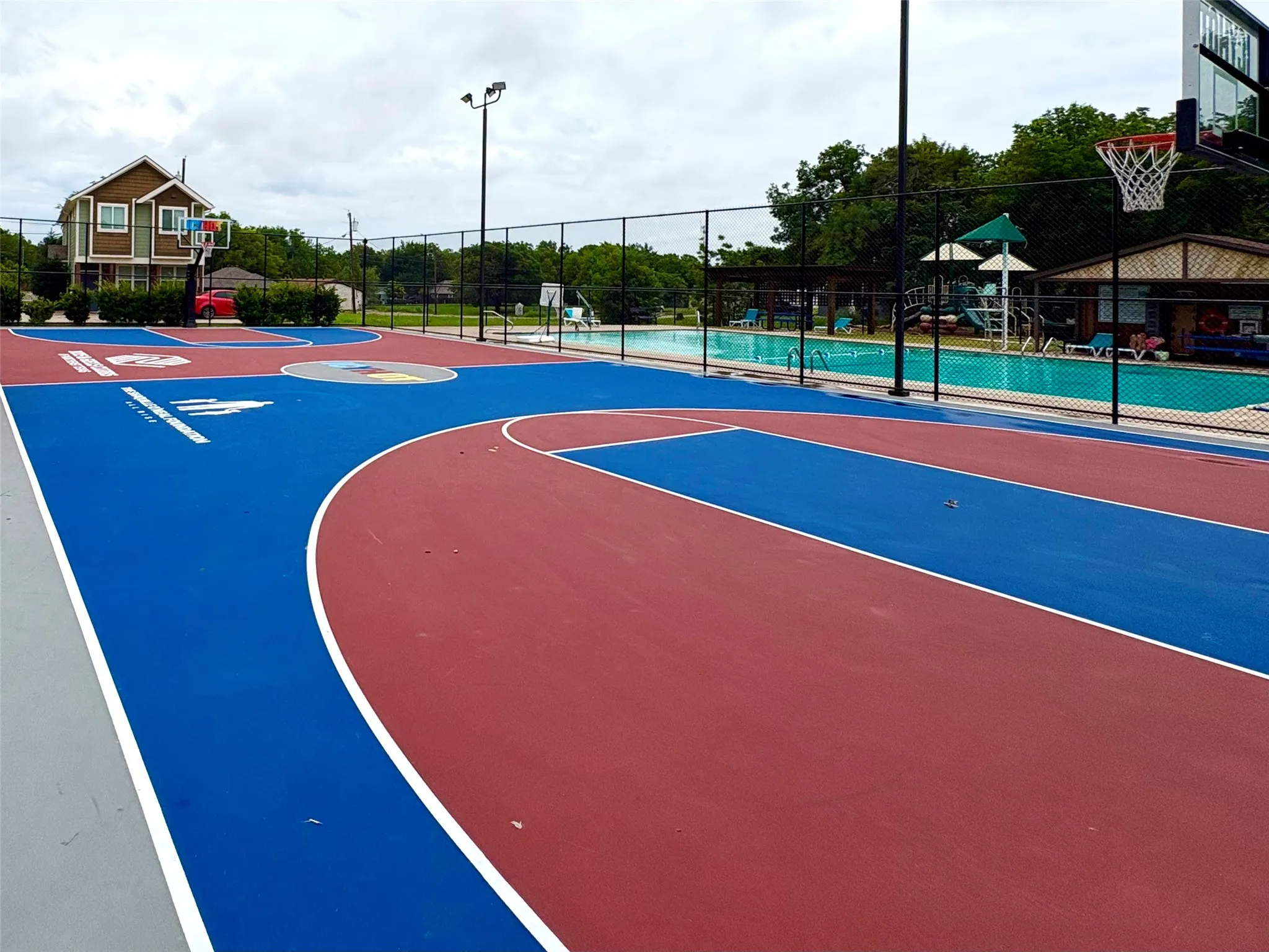 Multi-sport court featuring red and blue surfacing with white line markings