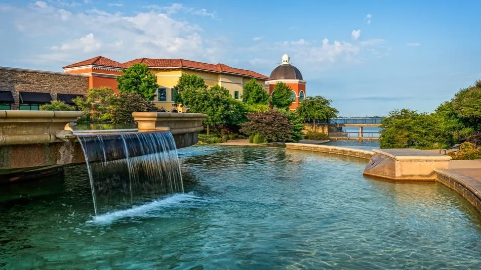 Water feature with cascading waterfall, surrounded by mature landscaping and architectural elements