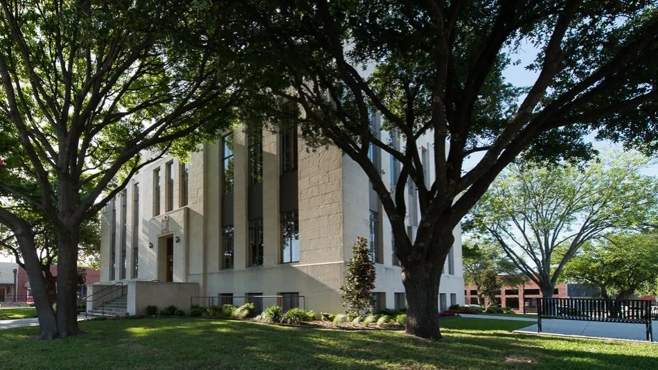 Stately building exterior featuring a stone facade and prominent vertical window lines