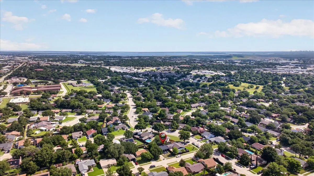Aerial perspective showcasing a residential neighborhood with mature tree coverage