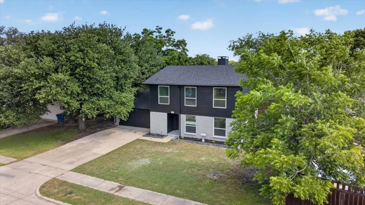 Contemporary two-story exterior with a contrasting dark upper facade and light lower stone-finish facade