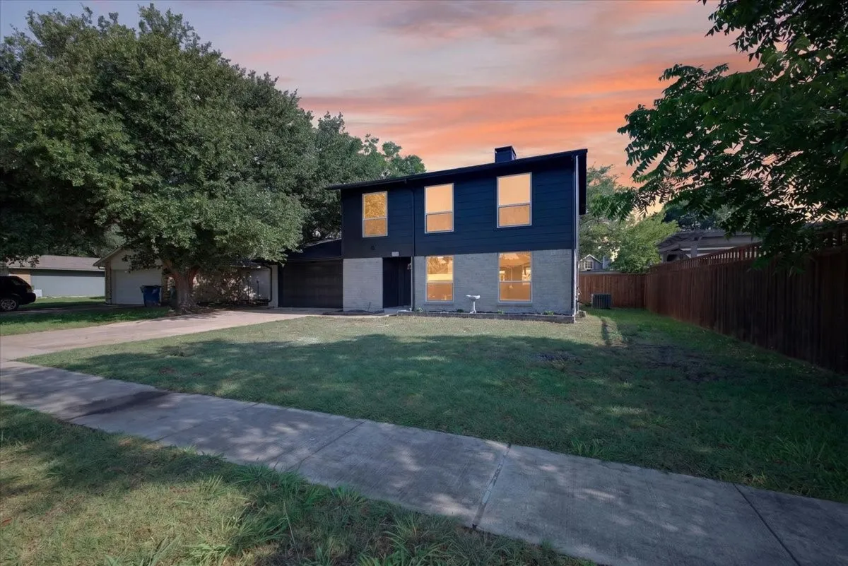 Two-story residence featuring a dark siding facade and a contrasting gray stone lower level