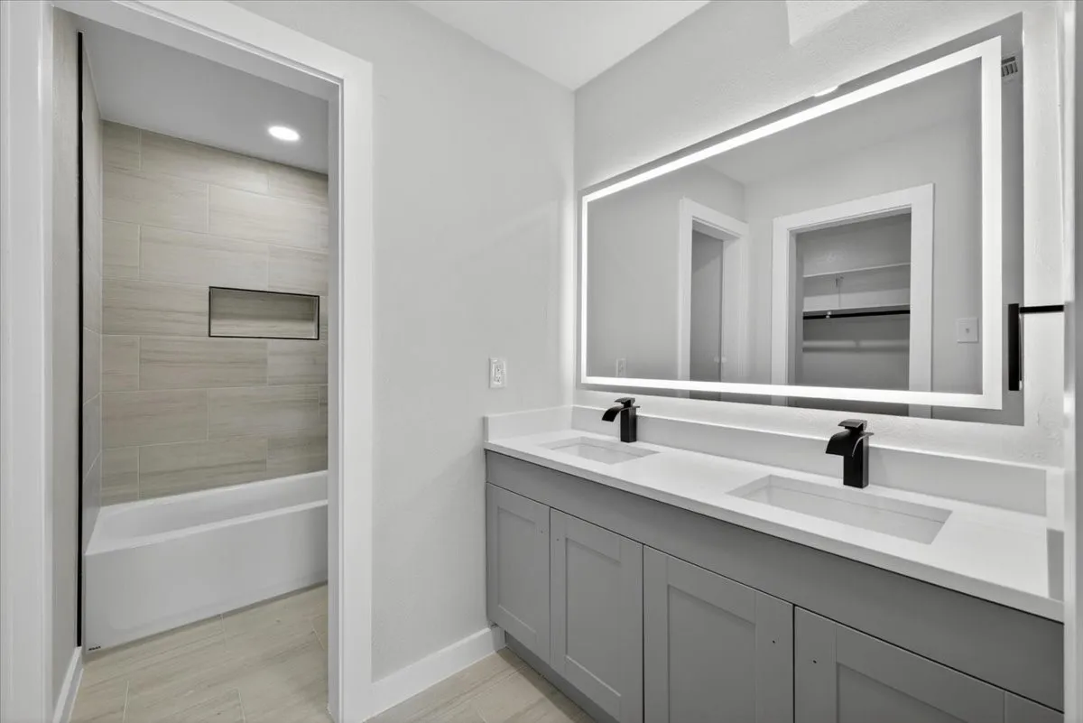 Dual vanity with undermount sinks, white countertops, and matte black fixtures