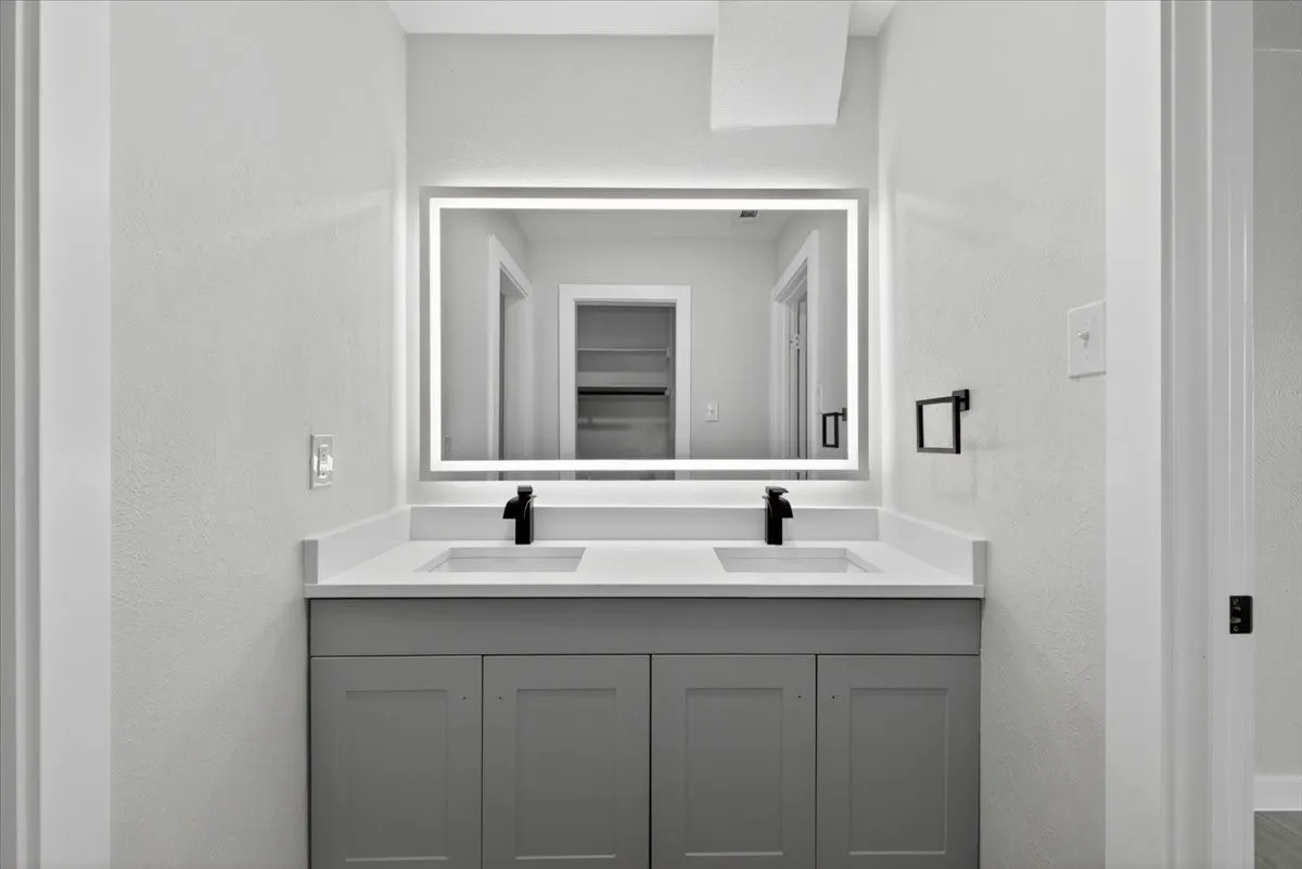 Double vanity with a light gray cabinet base, dual undermount sinks, and a light-toned countertop