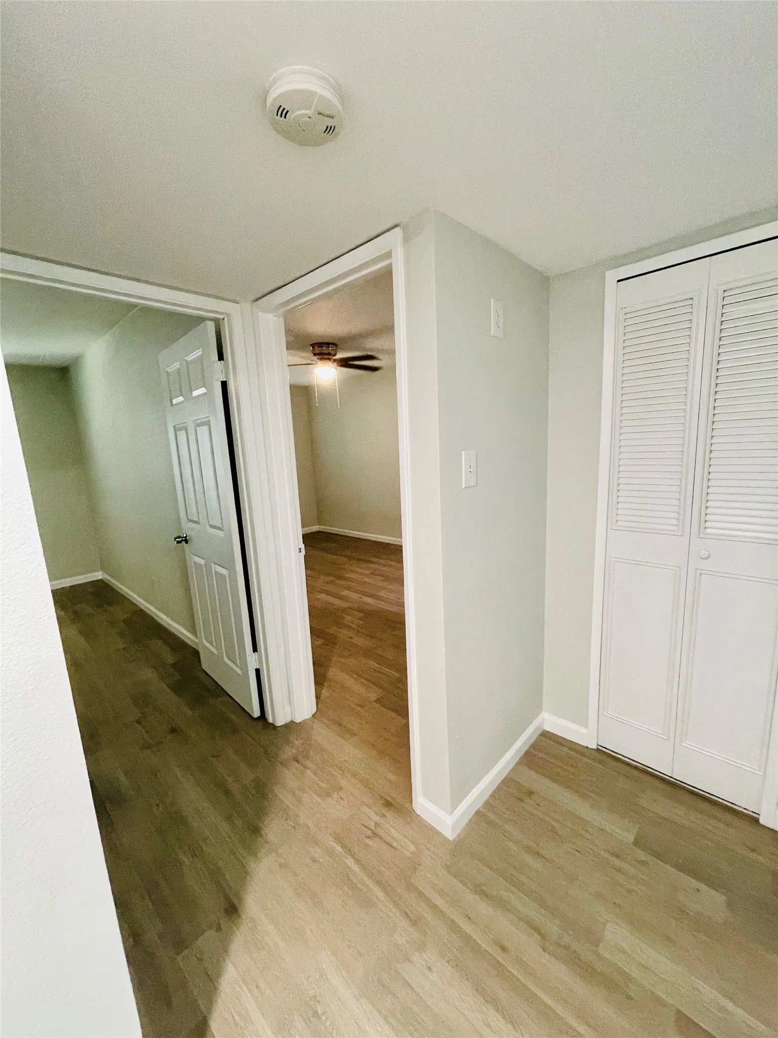 Corridor with light hardwood / wood-style flooring