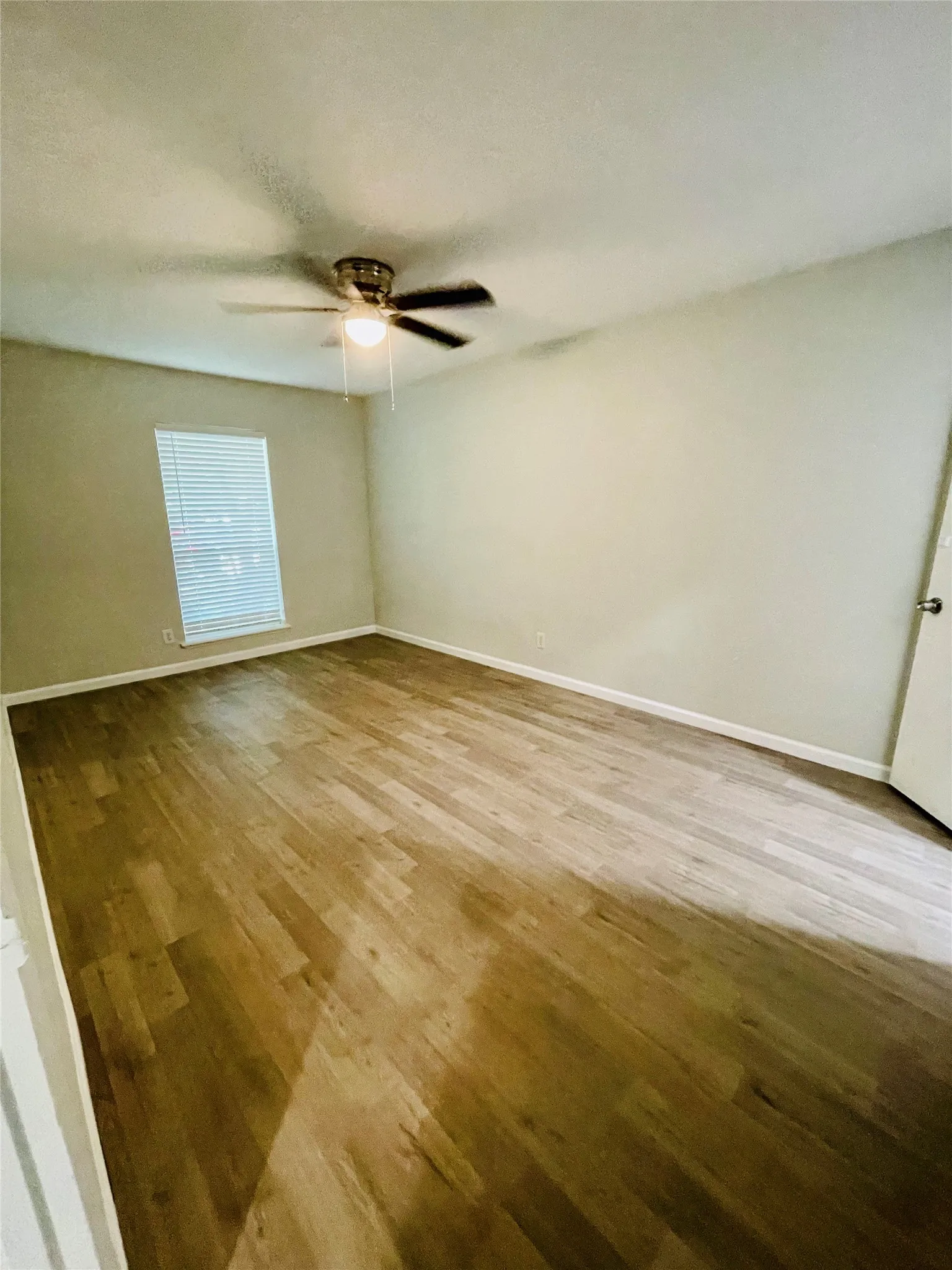 Empty room with ceiling fan and hardwood / wood-style flooring