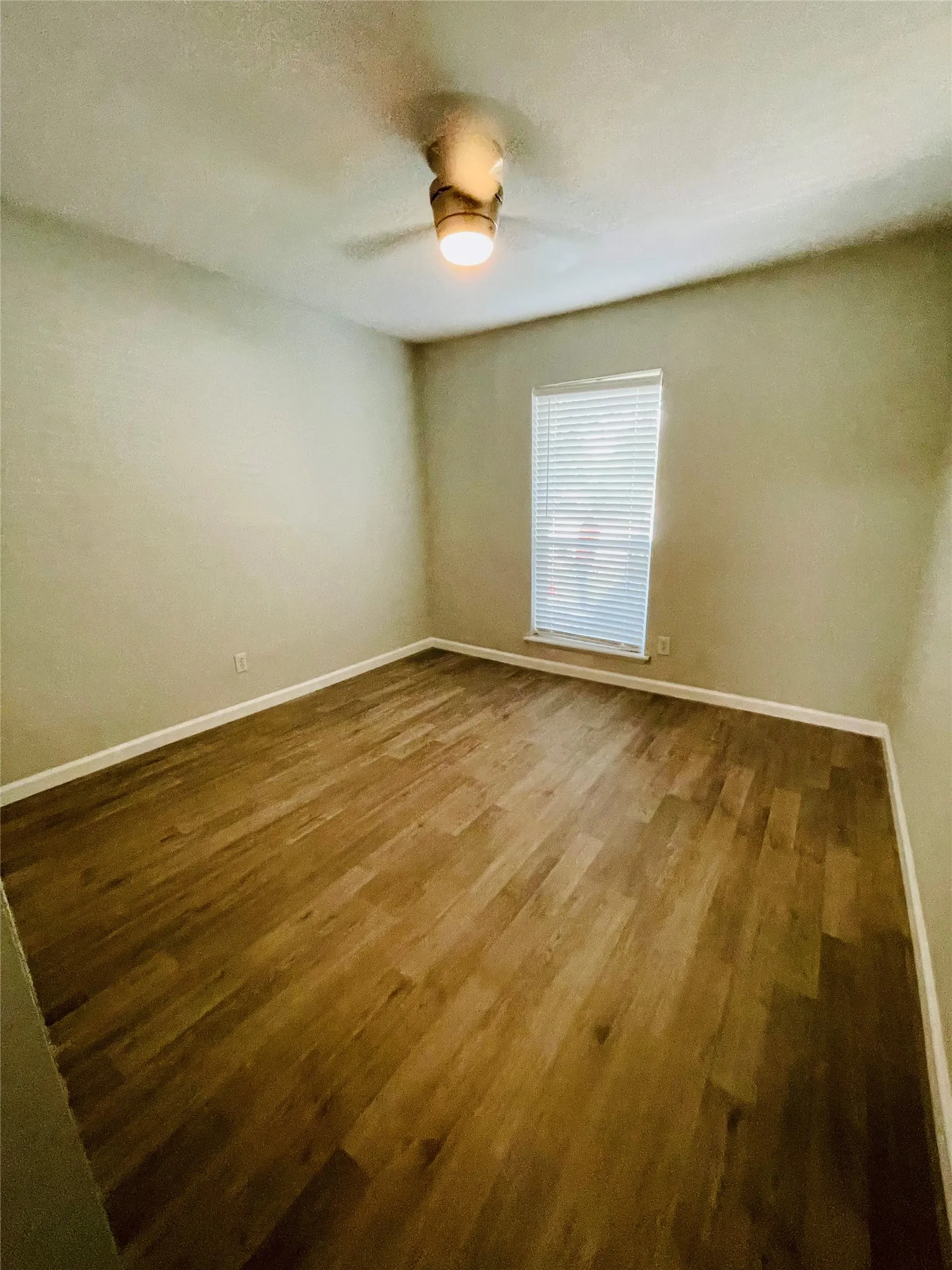 Unfurnished room featuring hardwood / wood-style floors and ceiling fan