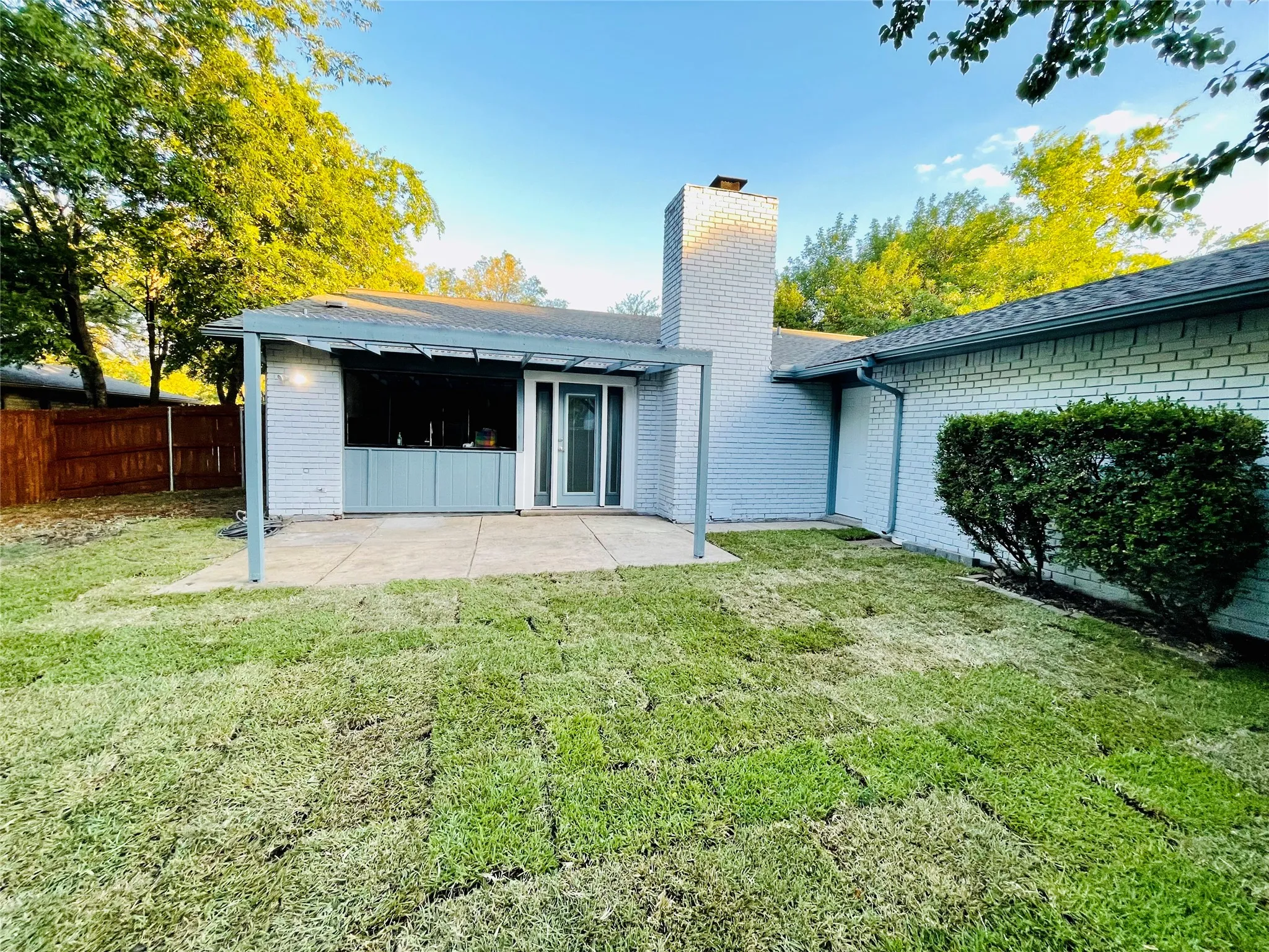 Back of house with a lawn and a patio area