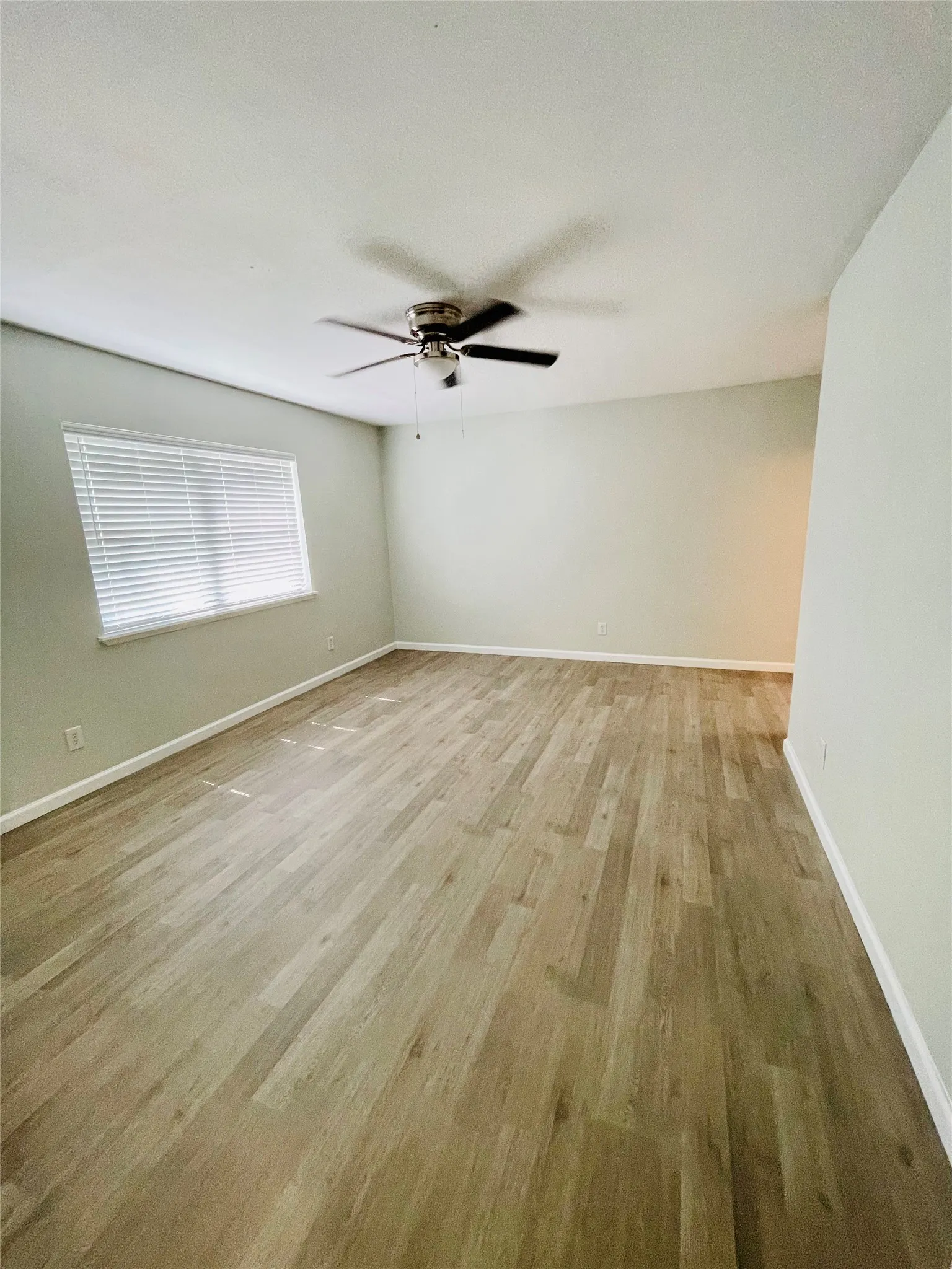Spare room with light wood-type flooring and ceiling fan