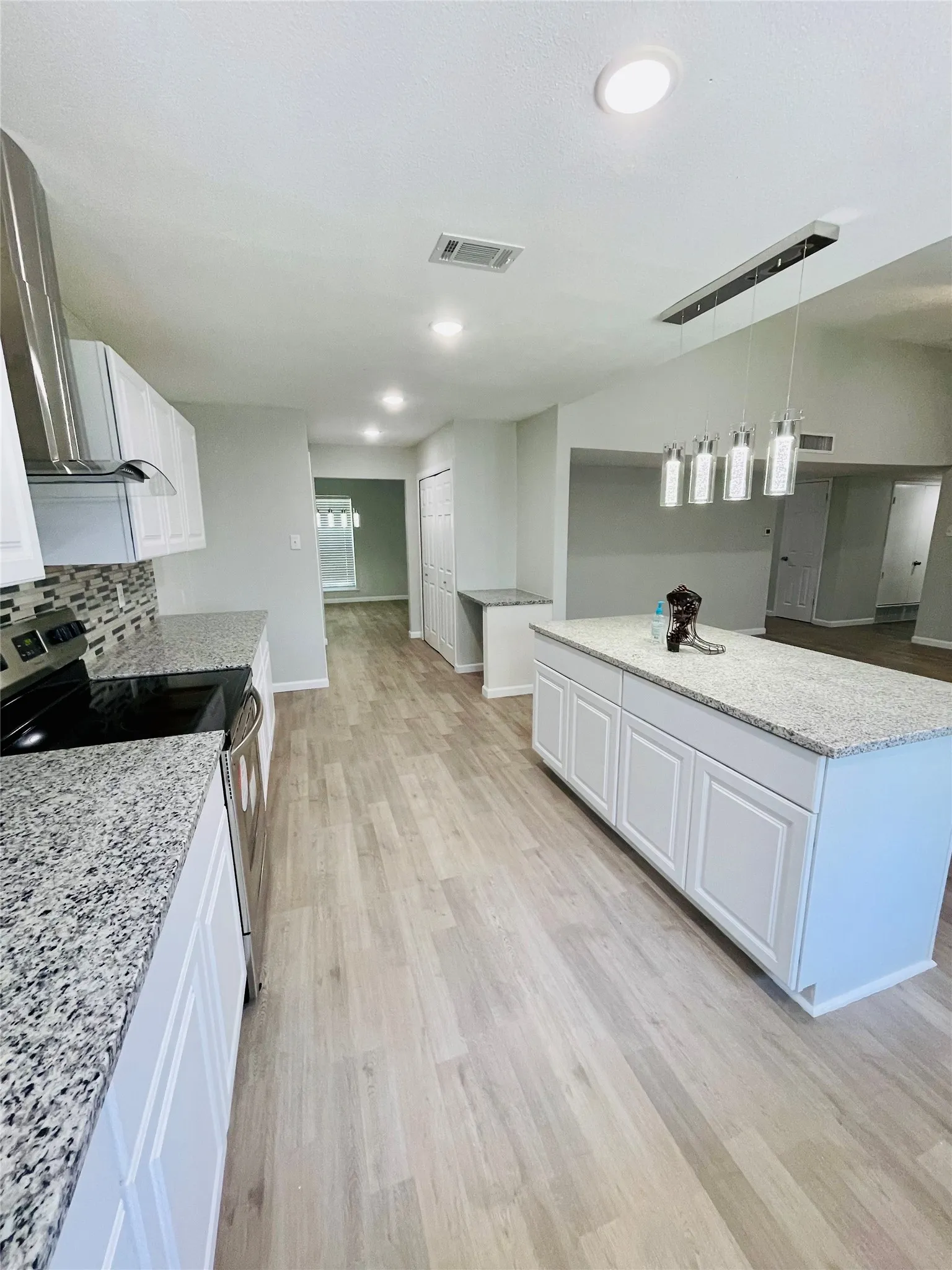 Kitchen with white cabinets and light hardwood / wood-style floors