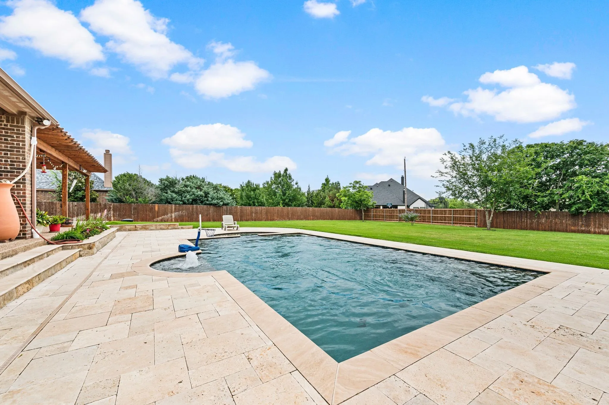 The gunite lap pool includes LED lighting and a built in bench with a bubbler water feature and a spa. Beautiful travertine provides ample deck space.
