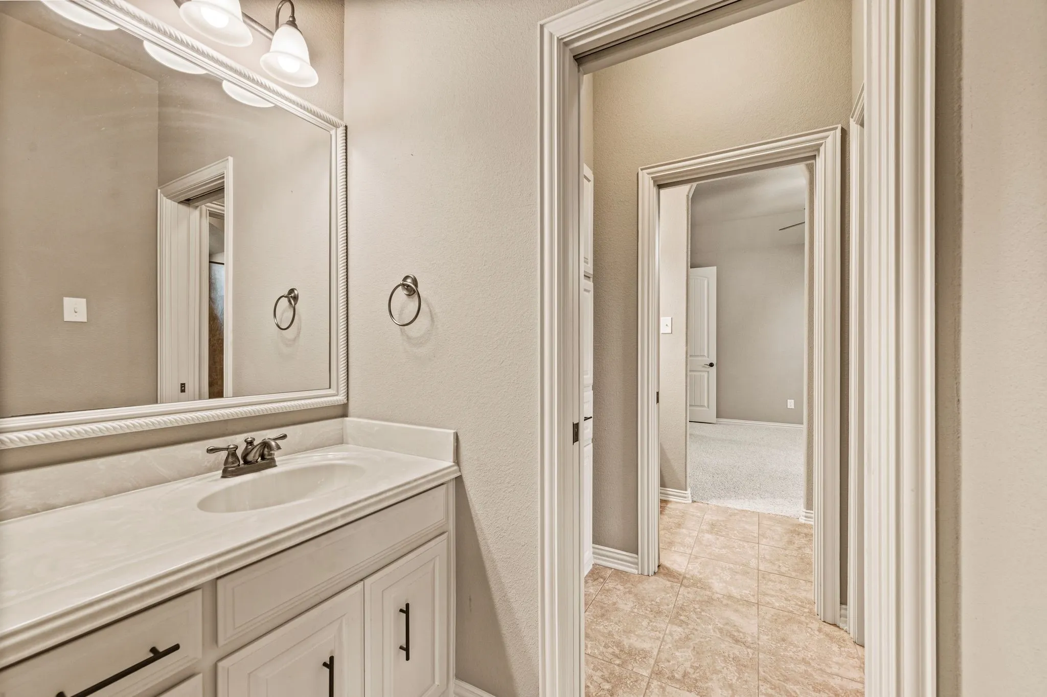 The Jack and Jill bathroom includes tile flooring, cultured marble vanity, framed mirror, and bronze fixtures and hardware. Each bedroom has it's own vanity. The shower-tub combination and toilet are shared.