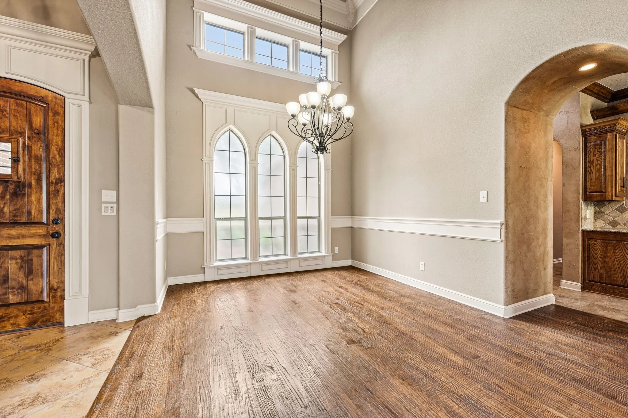 This impressive dining room has beautiful architectural details, a vaulted ceiling, chandelier and hand scraped hardwood floors that flow from here into the family room.