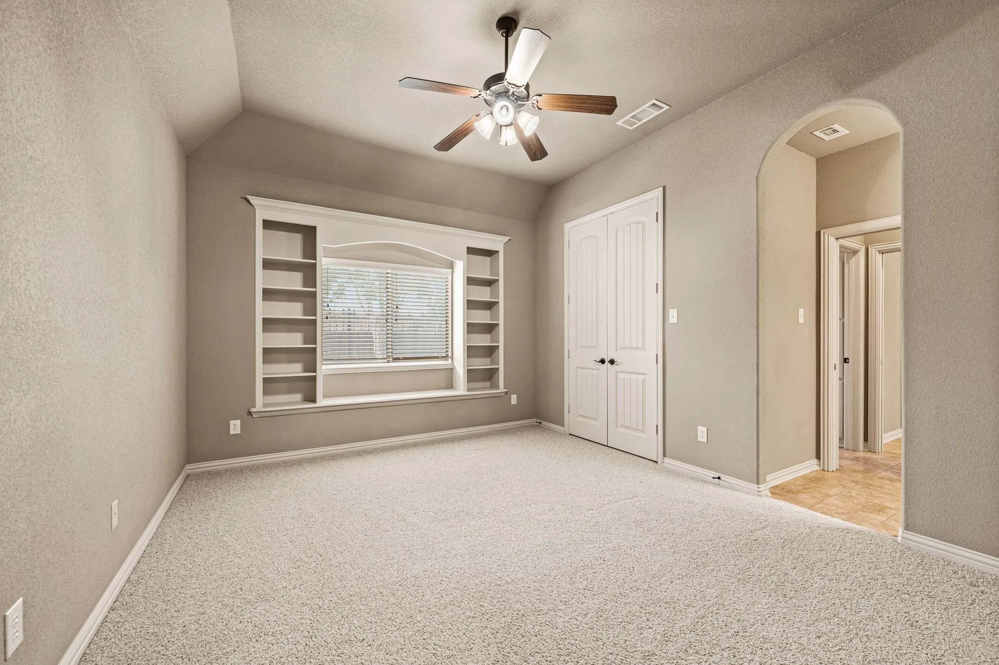 This third bedroom located downstairs includes built ins and window seating, a spacious double door closet, vaulted ceiling, ceiling fan and it's connected to a Jack and Jill bath.