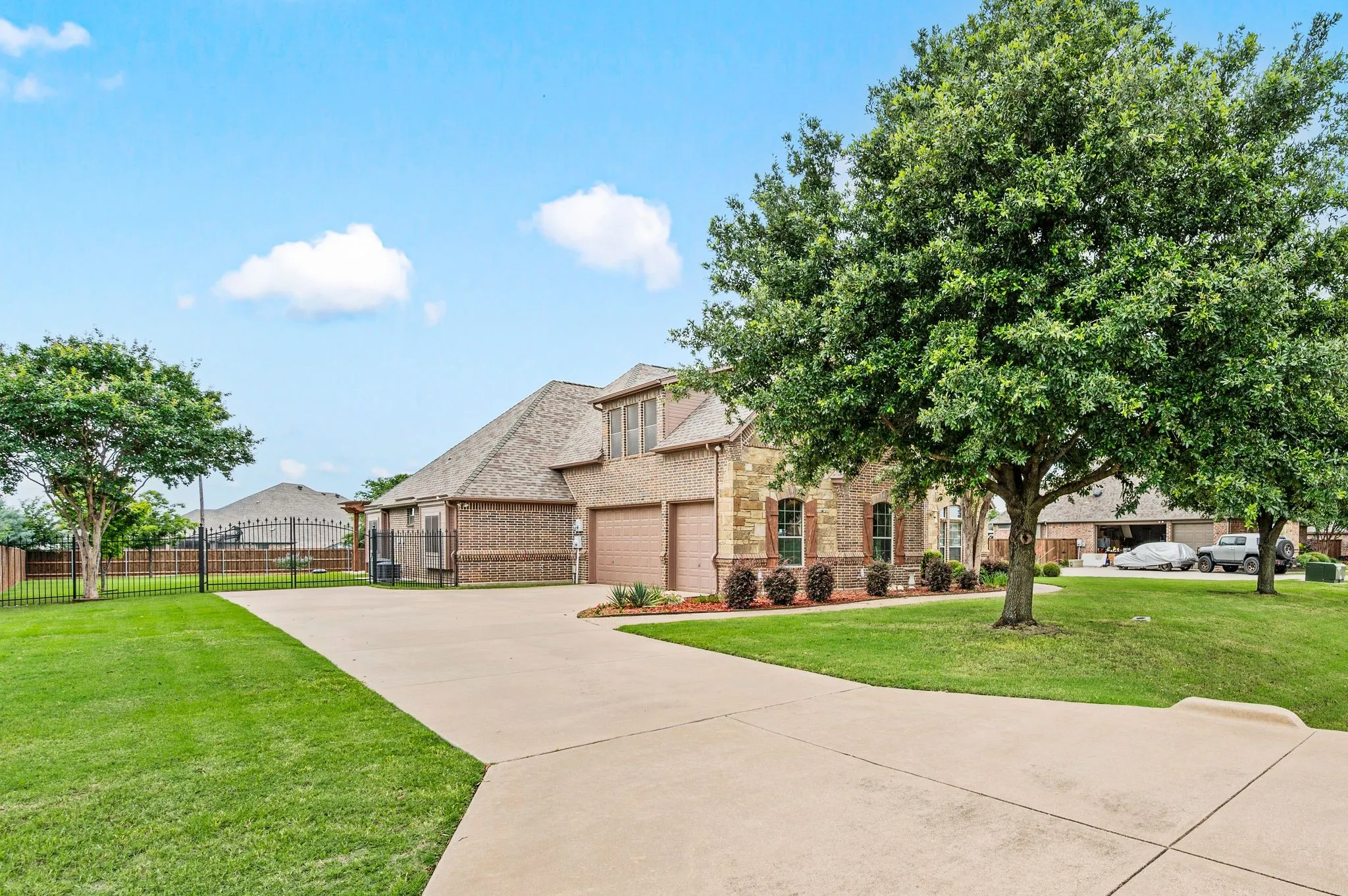 A wide and spacious driveway leads to a side entry 3 car garage.  A wrought iron gate on both front sides of the home secure the cedar fenced backyard.