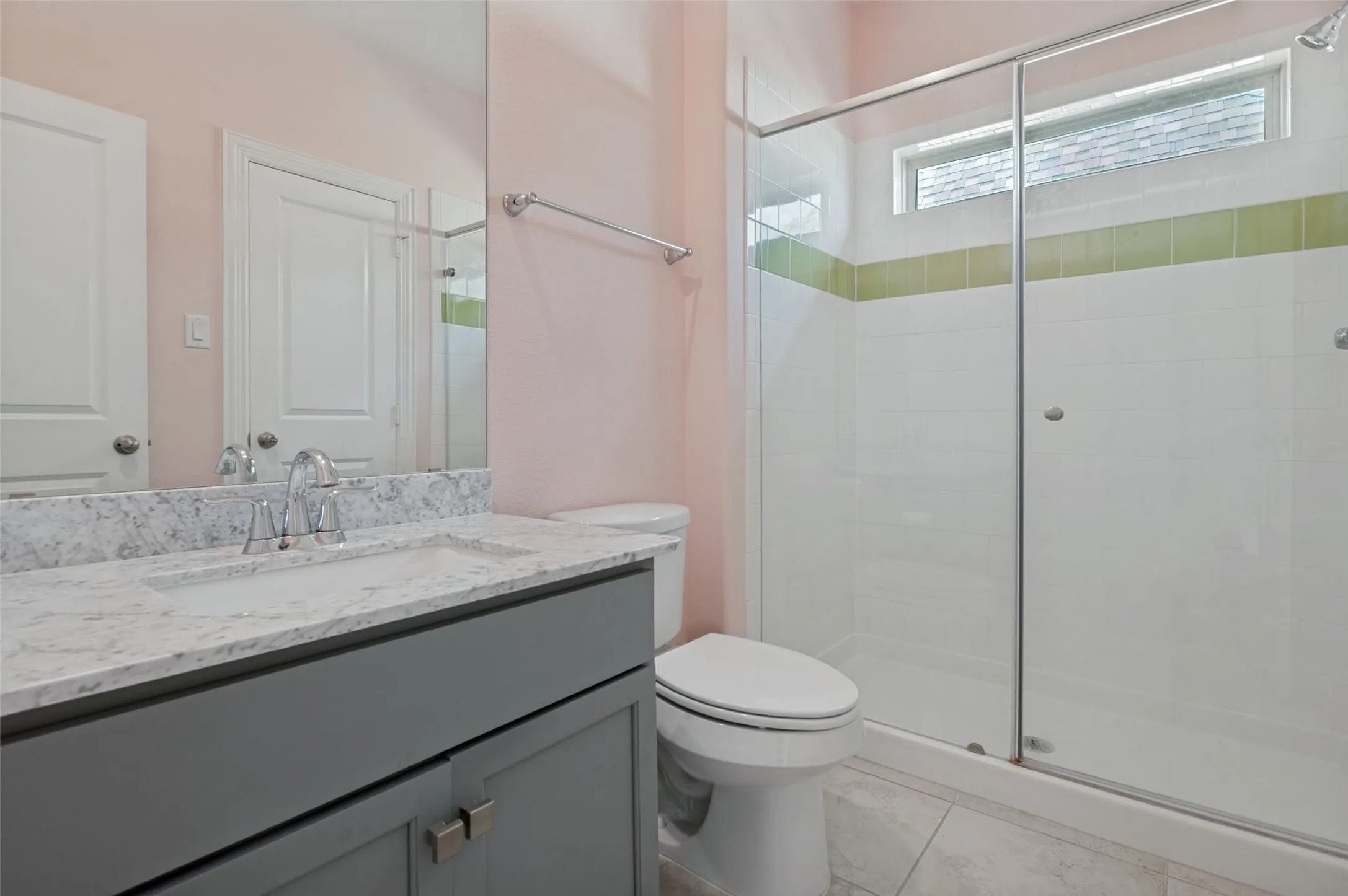Bathroom featuring a gray vanity with an integrated sink and light-toned countertop